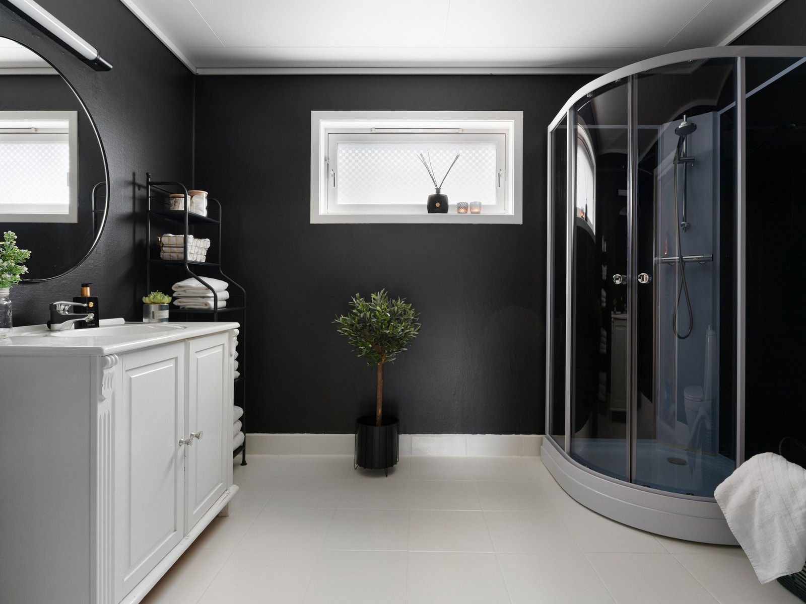 Badet i 1. etasje har fliser på gulv med gulvvarme og strietapet på veggene. Galleribilde