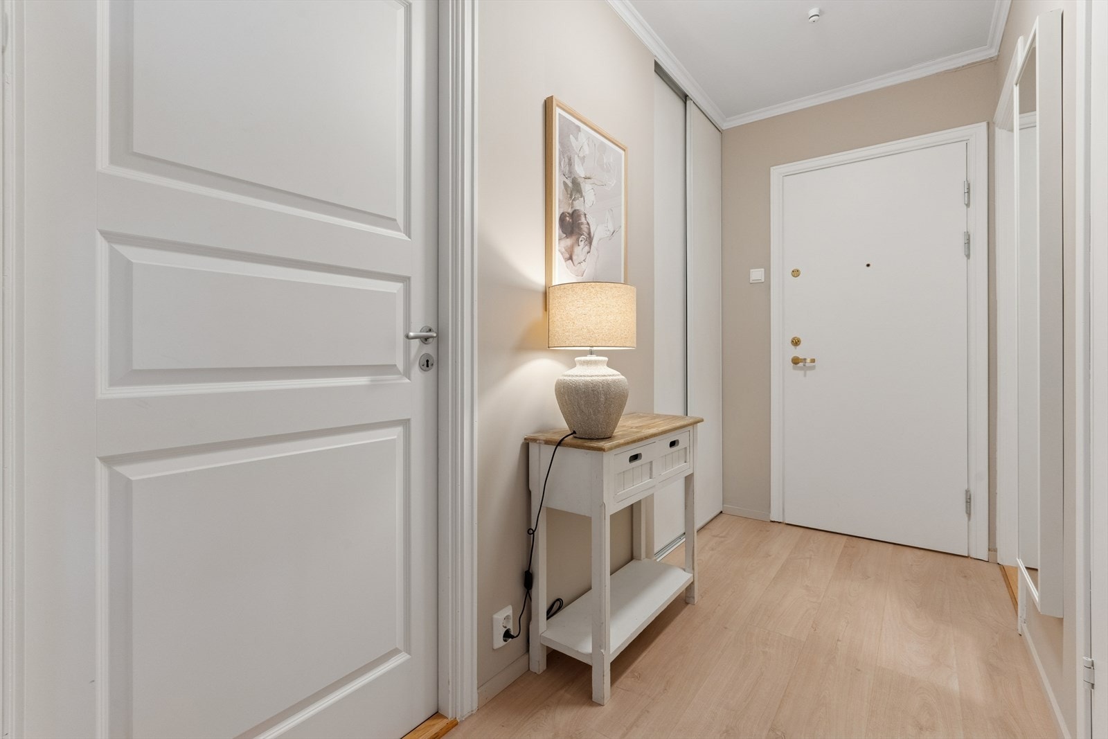 Her ønskes du velkommen inn i en lys entré med god plass til å oppbevare ytterklær og sko i en praktisk skyvedørsgarderobe. Galleribilde