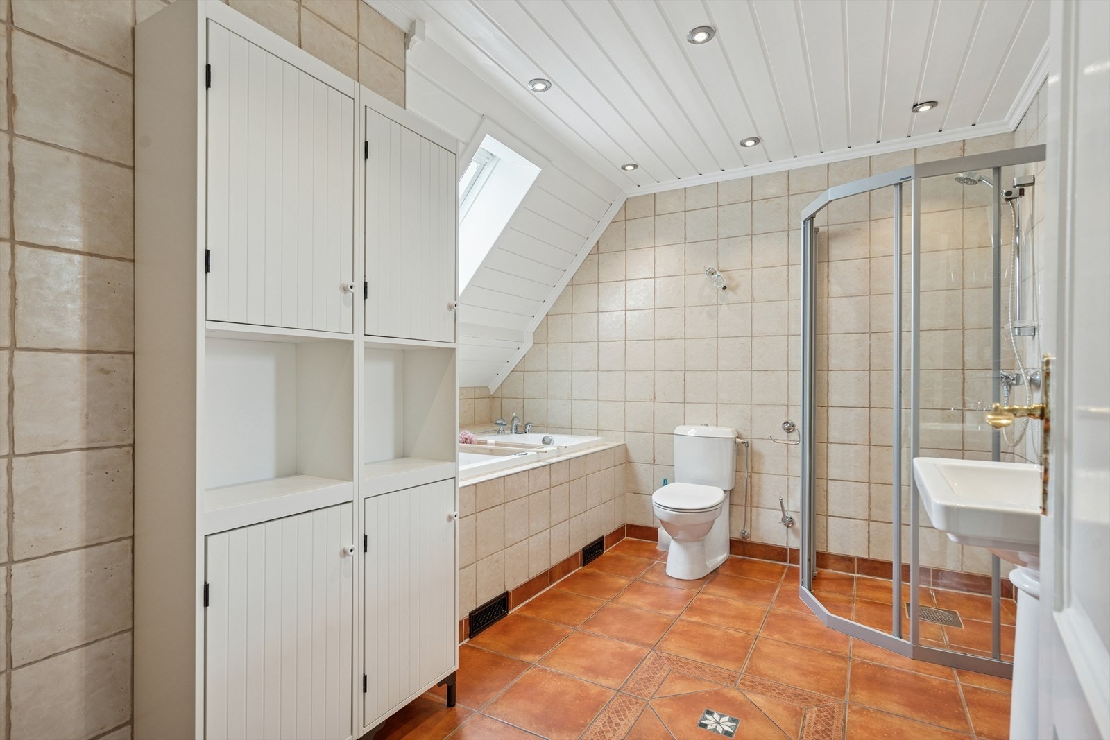 Badet i andre etasje er flislagt og er utstyrt med både et herlig badekar og dusjhjørne. Galleribilde