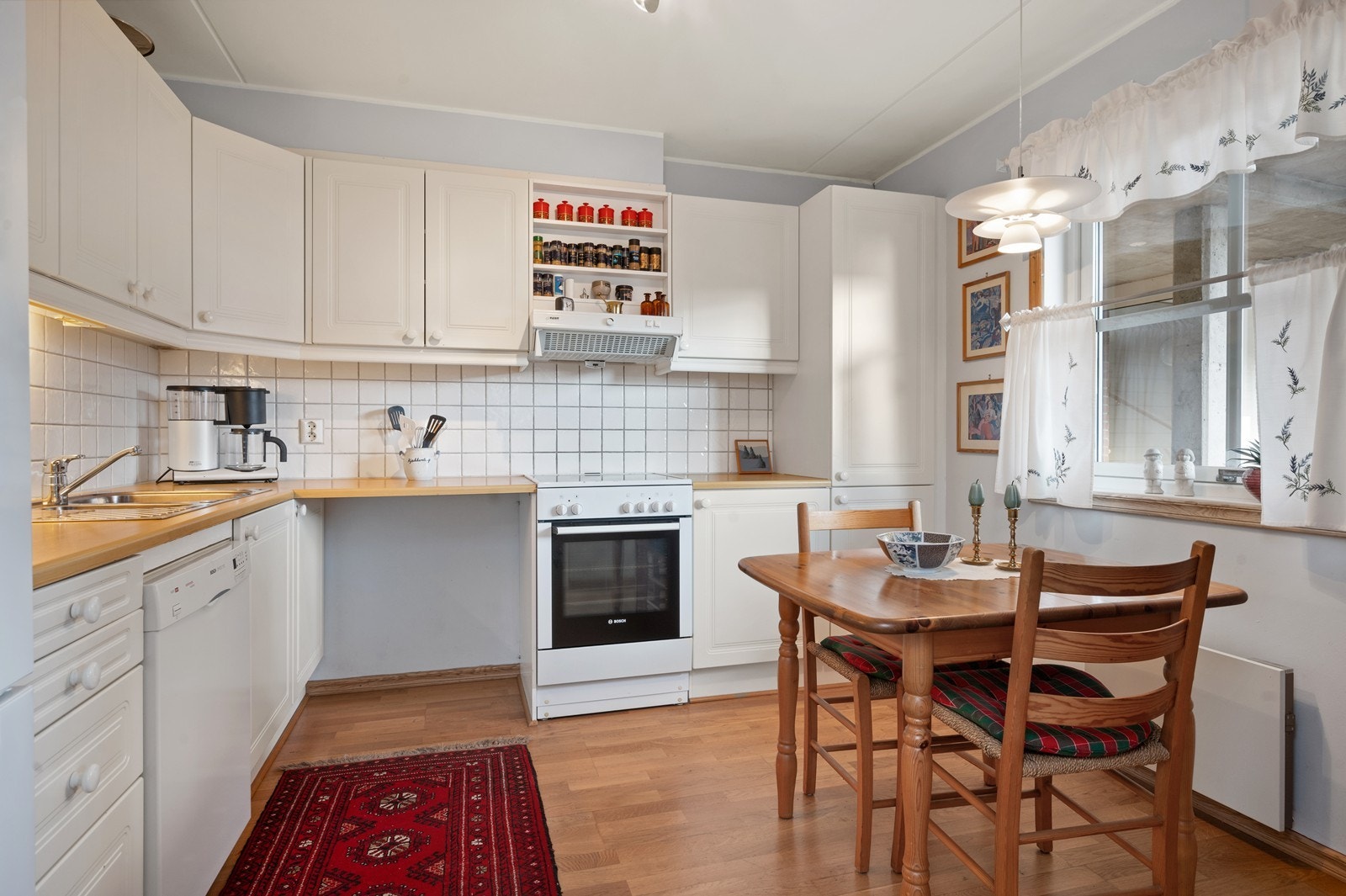 Lyst kjøkken med god plass til både spisebord og praktisk oppbevaring. Galleribilde