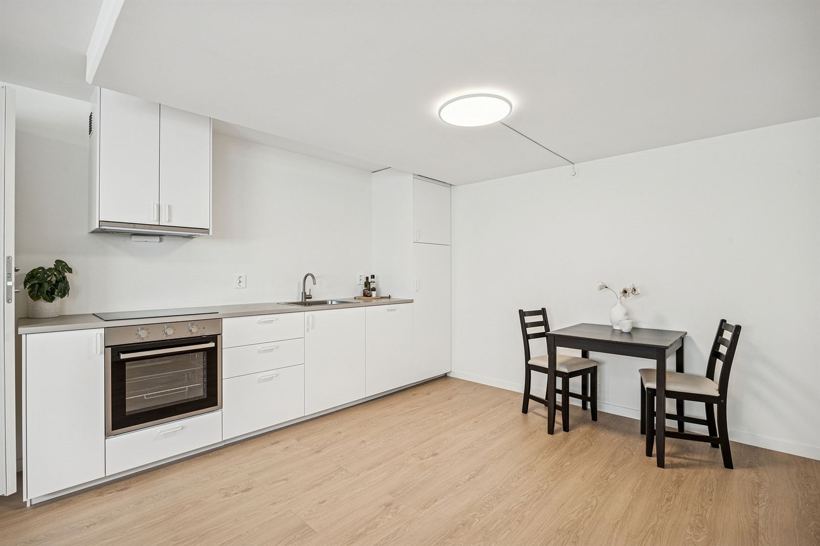 Hybeldelen har en åpen stue- og kjøkkenløsning. Kjøkkenet er innredet med hvite, matte fronter fra Ikea, benkeplate i laminat, rustfri oppvaskkum og integrerte hvitevarer. Galleribilde