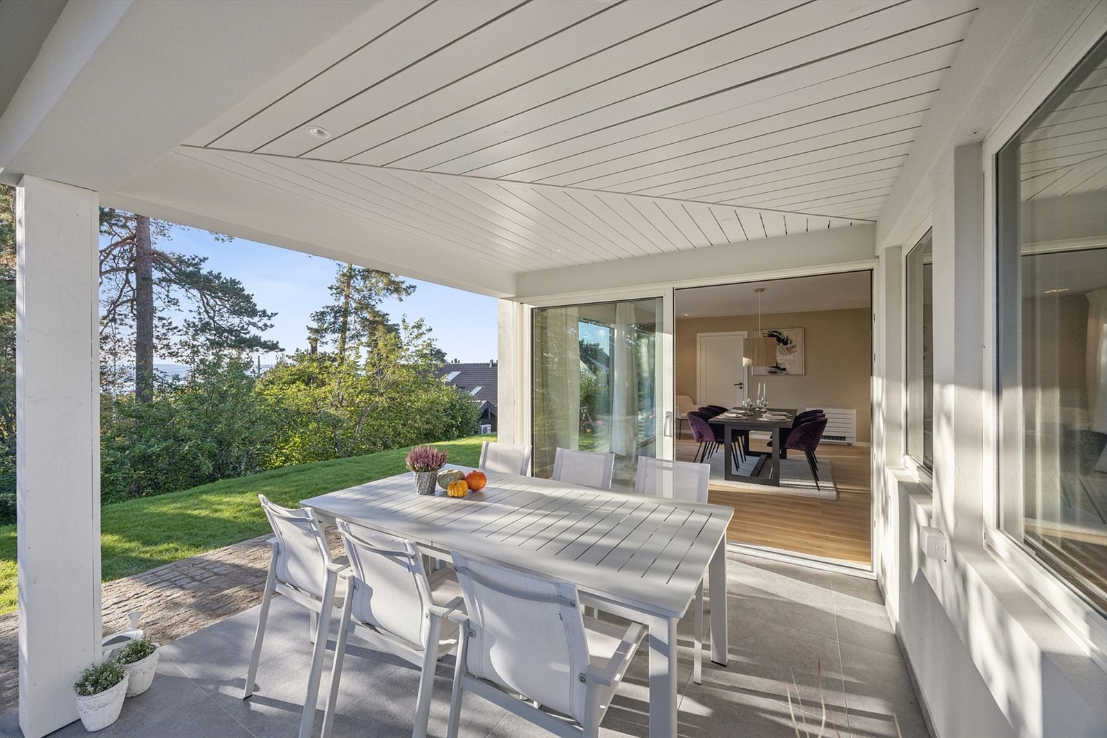 Adkomst fra stue/kjøkken til flislagt terrasse på 10 kvm., ideell for solrike ettermiddager og hyggelige måltider ute. Videre til pent opparbeidet hage. Galleribilde