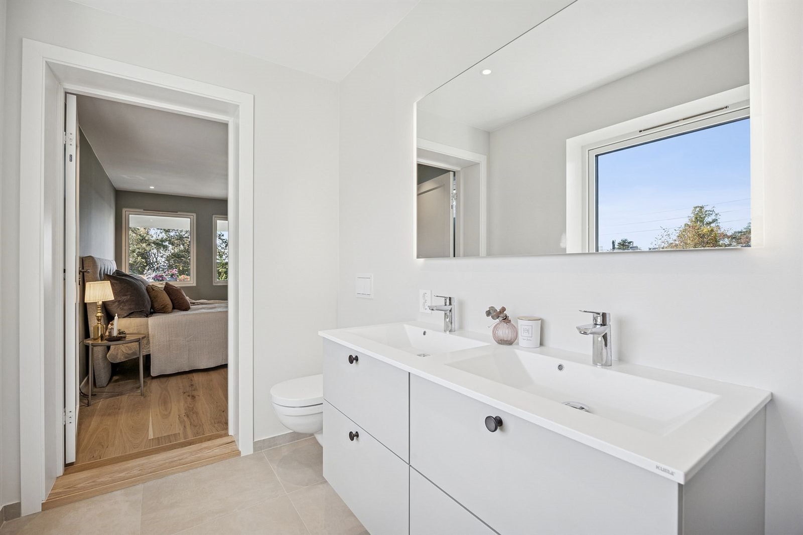 Badet tilknyttet hovedsoverommet og holder høy standard, med dobbel servant, moderne armaturer og en romslig dusjsone med to dusjhoder og glassdører. Galleribilde