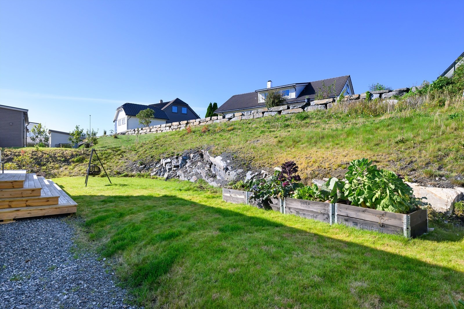 På baksiden er det plantet bærbusker av ulikt slag, og her er god boltreplass for lek og moro for hele familien Galleribilde