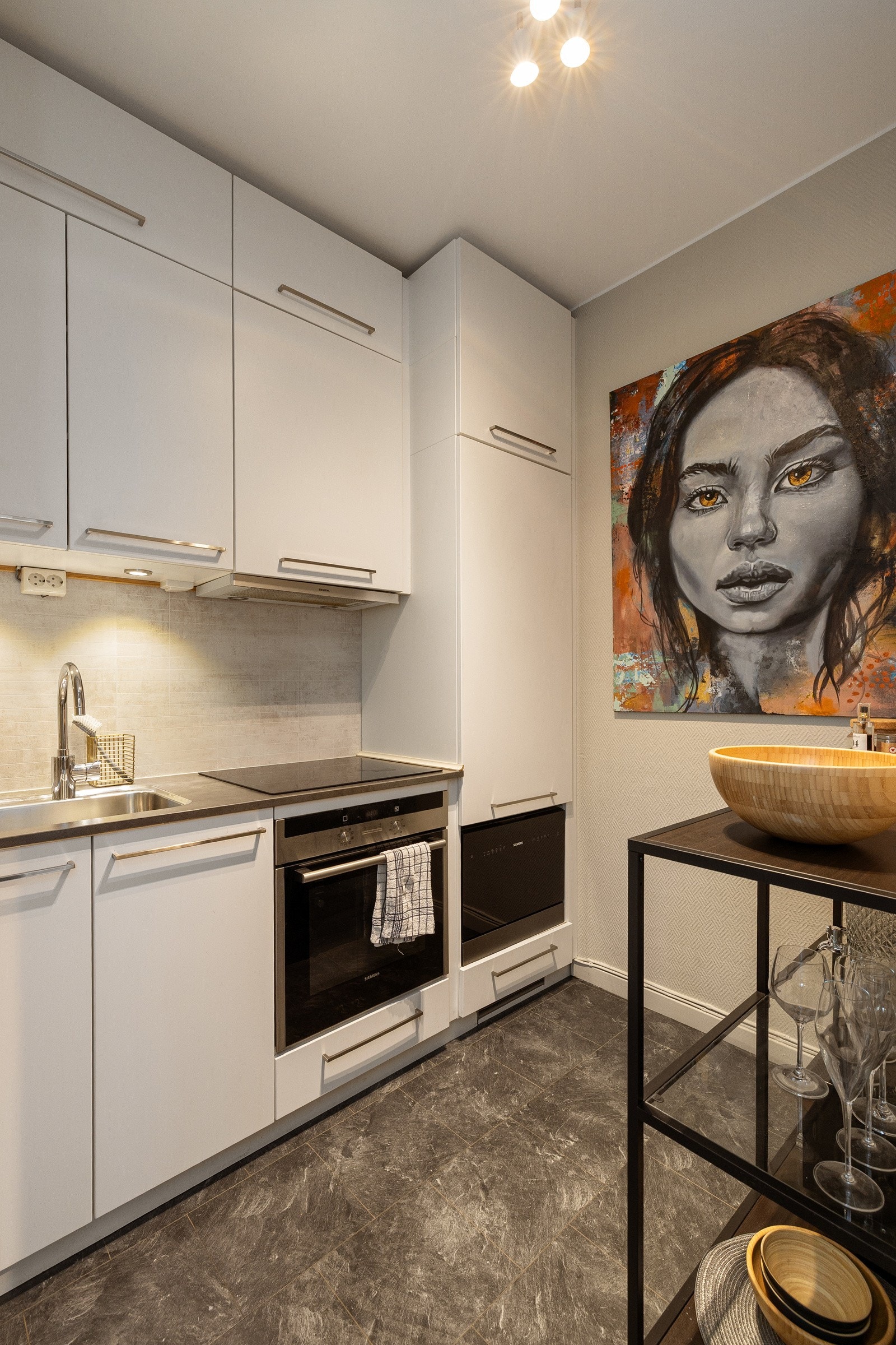 Leiligheten har et pent kjøkken med lyse fronter og en benkeplate i laminat med nedsenket oppvaskkum. Galleribilde