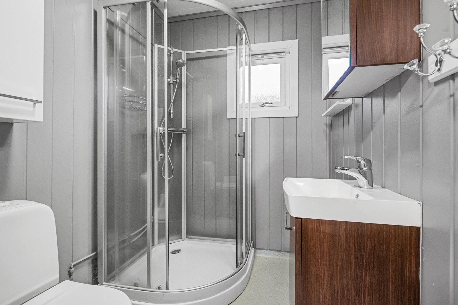 Badet har installert dusjkabinett, vask med underskap og toalett Galleribilde