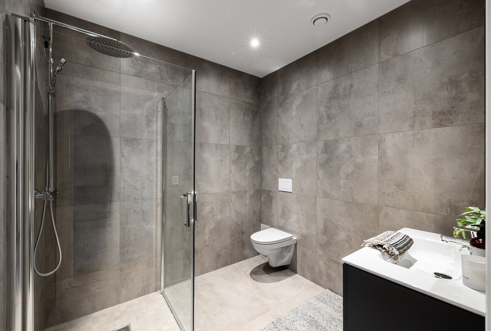 Utstyrt med dusjhjørne med regnfallsdusj, vegghengt toalett og servantinnredning. Galleribilde