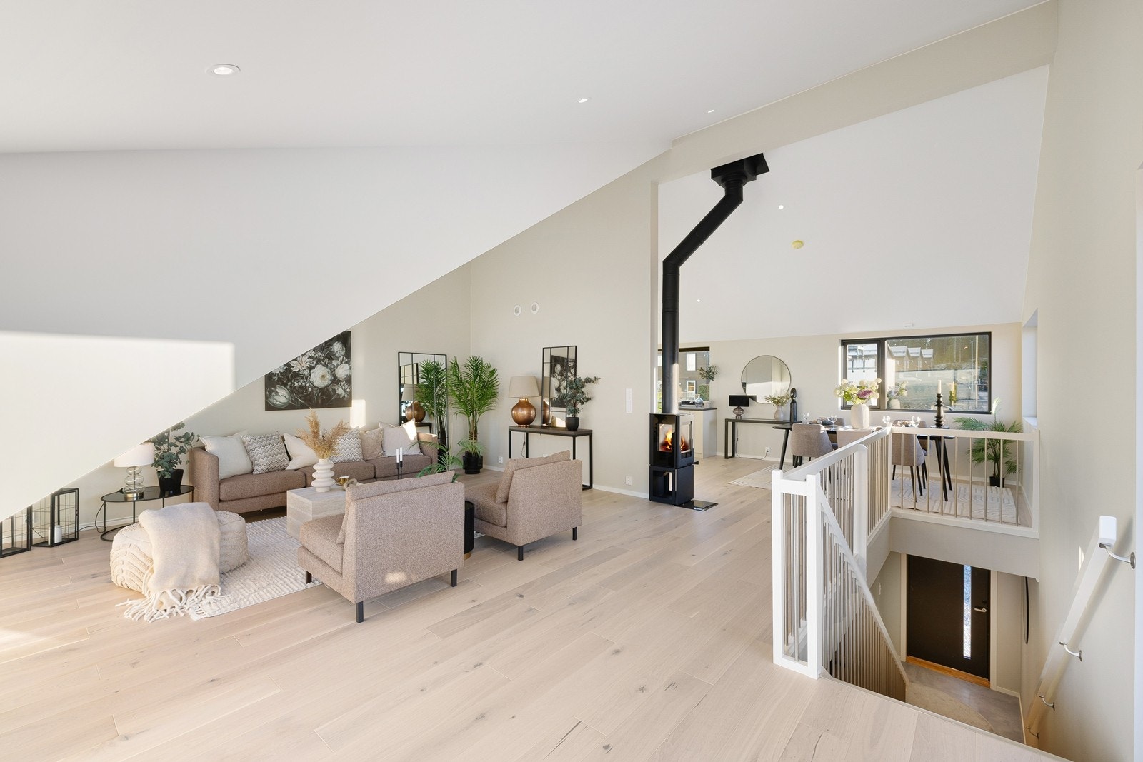 Trappen leder opp til en luftig stue og kjøkkenløsning med ekstra takhøyde. Galleribilde