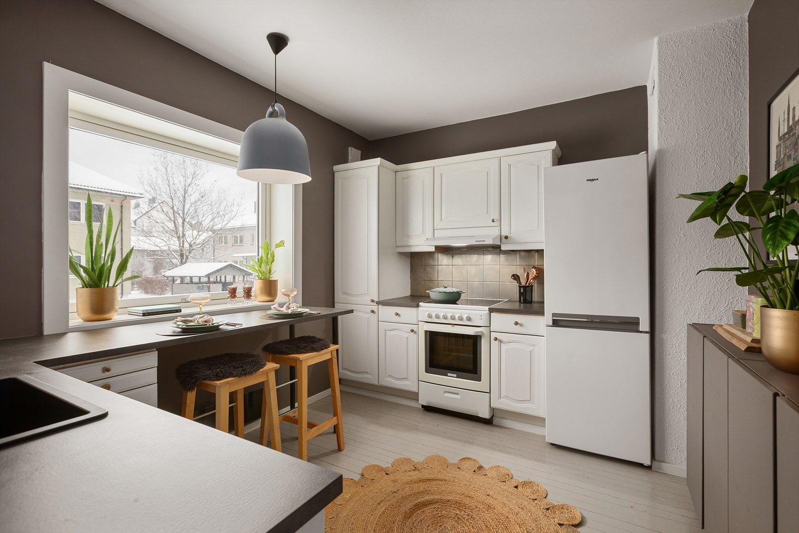 Pent kjøkken med profilerte fronter, flislagt over kjøkkenbenk og benkeplate av laminat som er byttet ut i 2020 Galleribilde