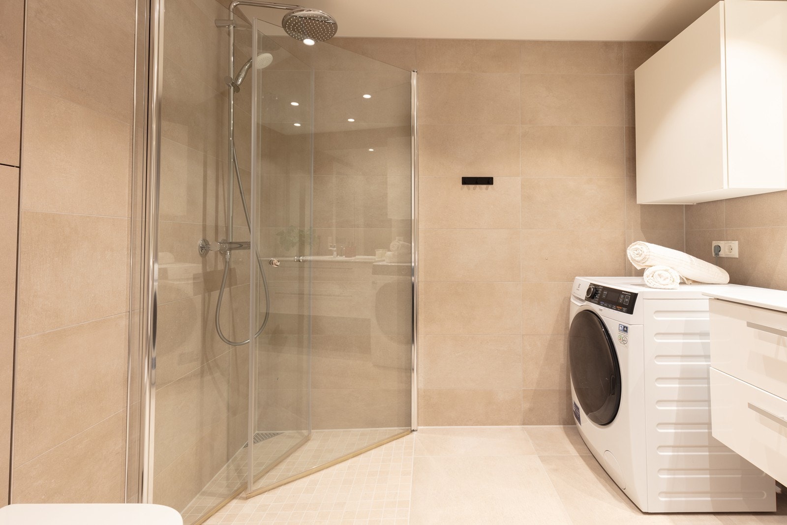 Dusjhjørne med glassdører og et Grohe-armatur med både håndholdt og regnfallsdusj. Galleribilde