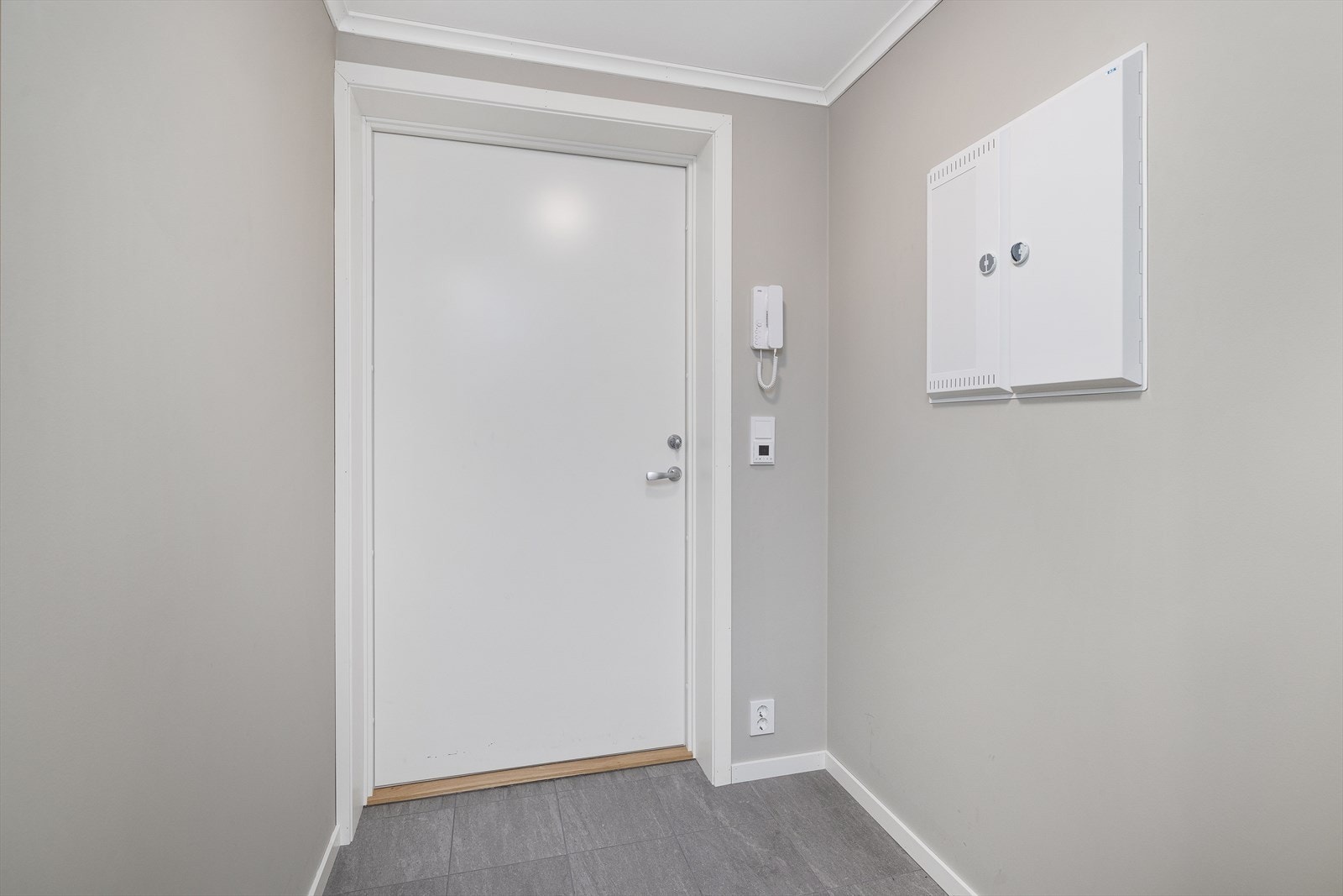 Velkommen inn i en lys entré med porttelefon og adkomst til alle rom. Galleribilde