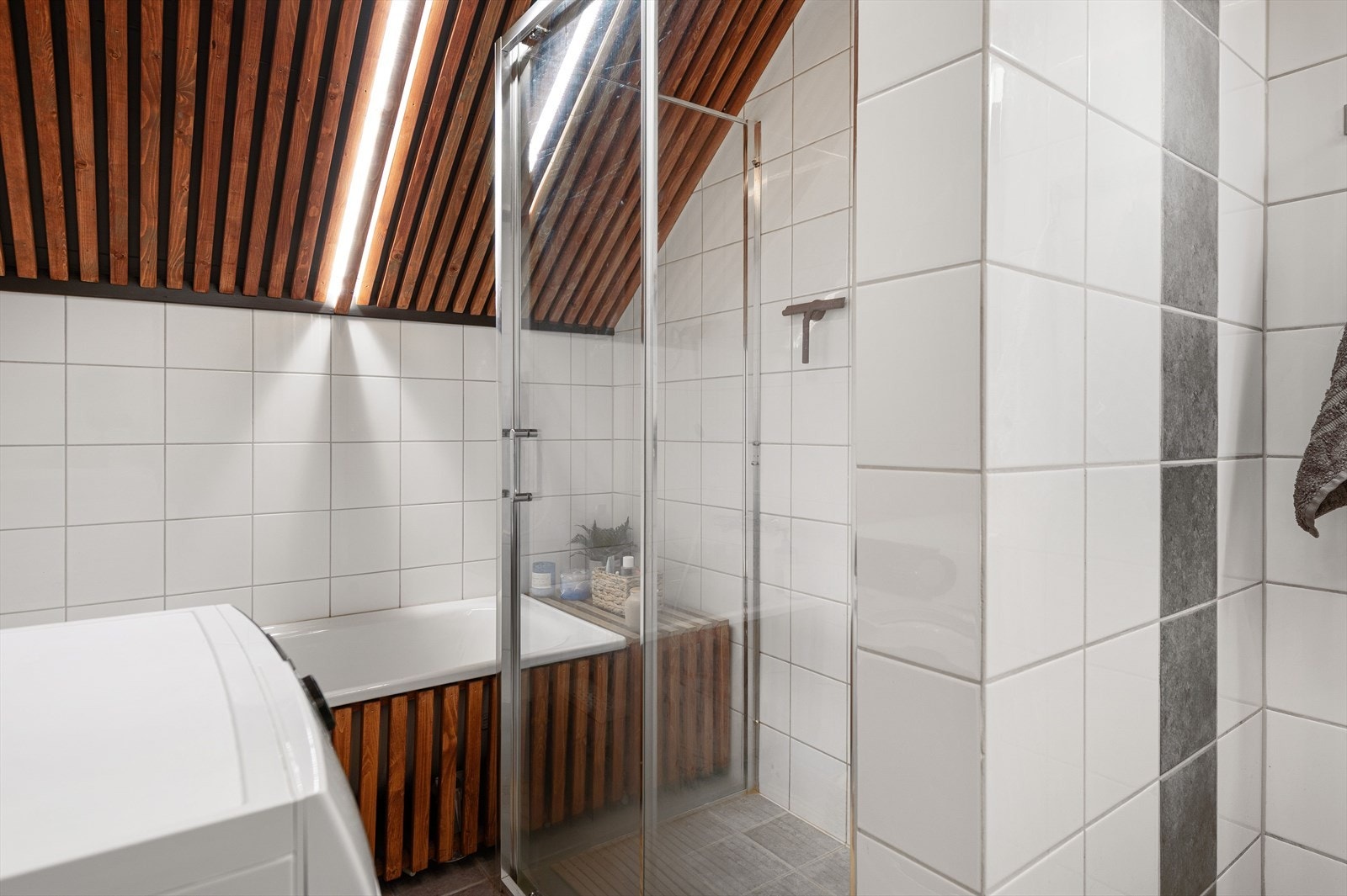 Trespiler i taket gir en stilfull helhet til leiligheten og og dusjhjørne en effektiv våtromsløsning. Galleribilde