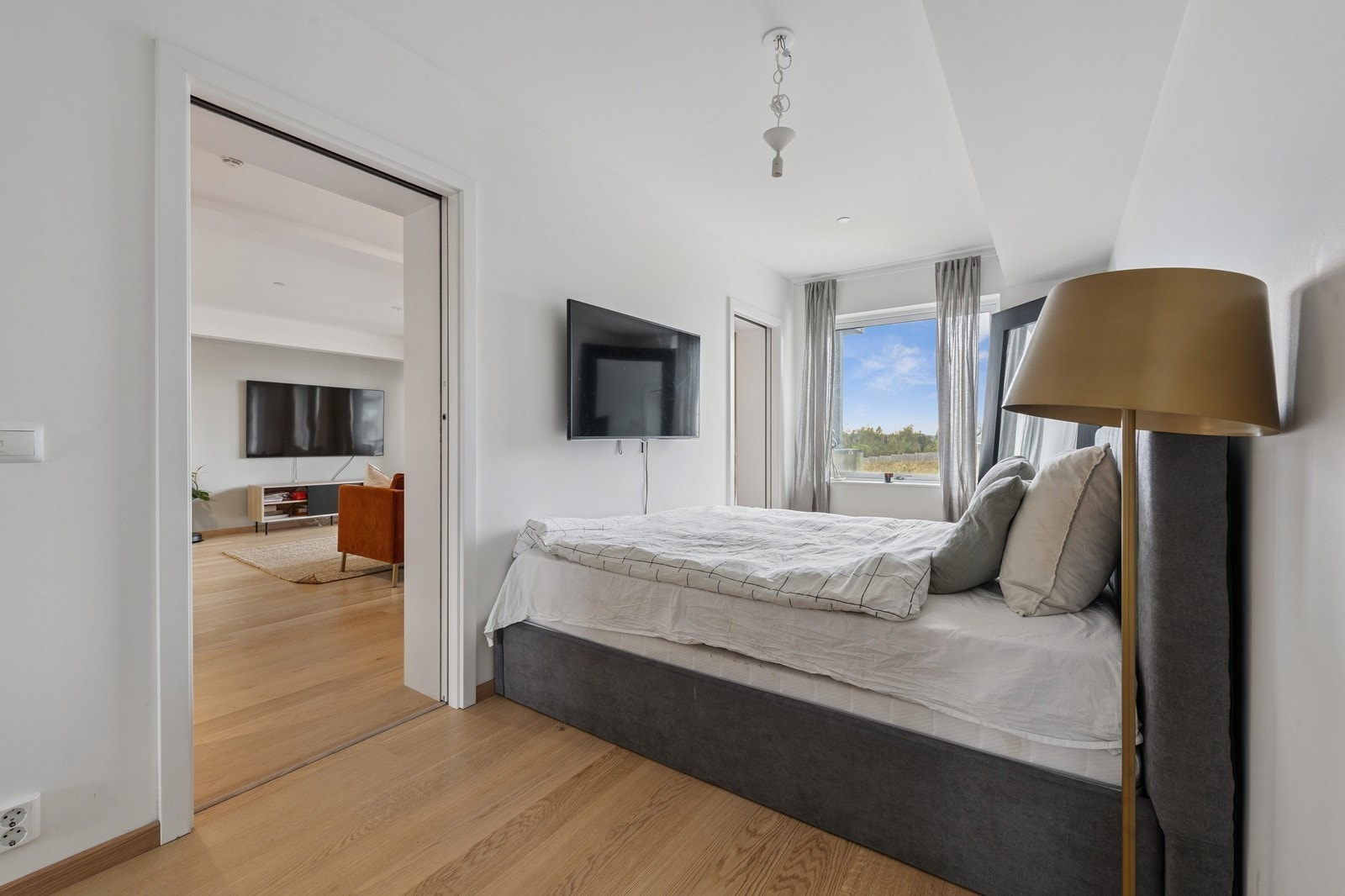 Hovedsoverommet er innredet med en komfortabel dobbeltseng med tilhørende nattbord. Galleribilde