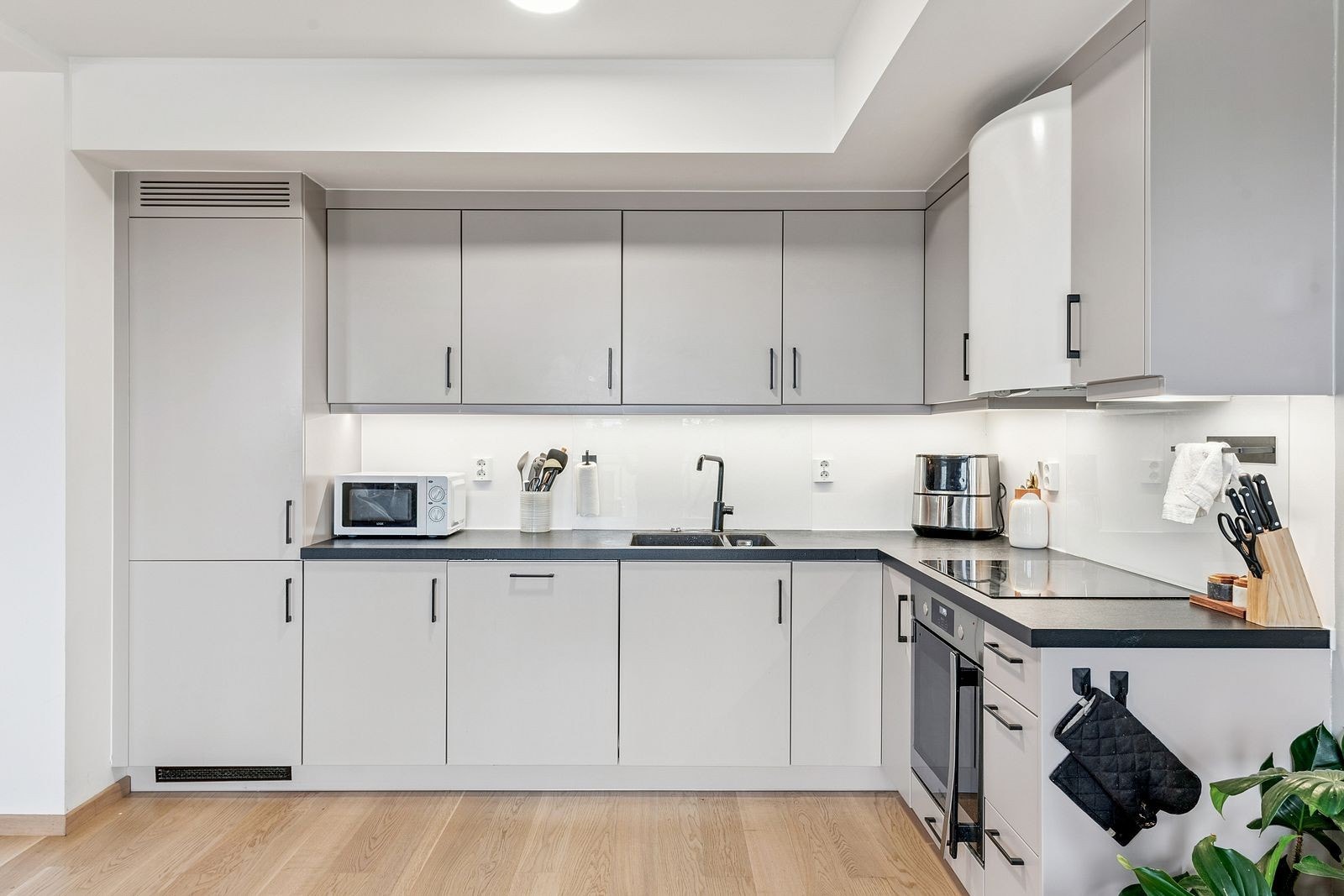 Alle nødvendige hvitevarer er integrert, inkludert kokeplate, ovn, mikro, oppvaskmaskin og kombiskap Galleribilde