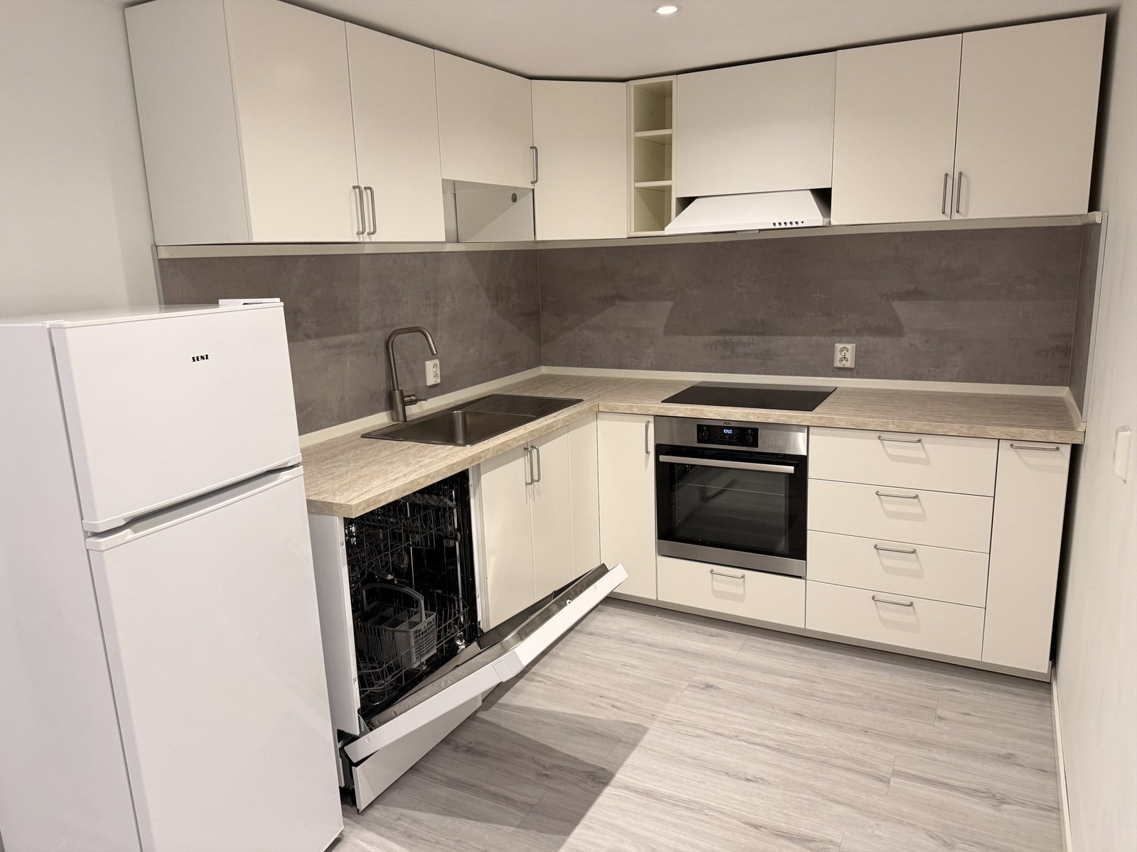 Etasjen har pen åpen kjøkkenløsning fra 2021 med kjøkkeninnredning med slette fronter og laminert benkeplate. (Selgers egne bilder). Galleribilde