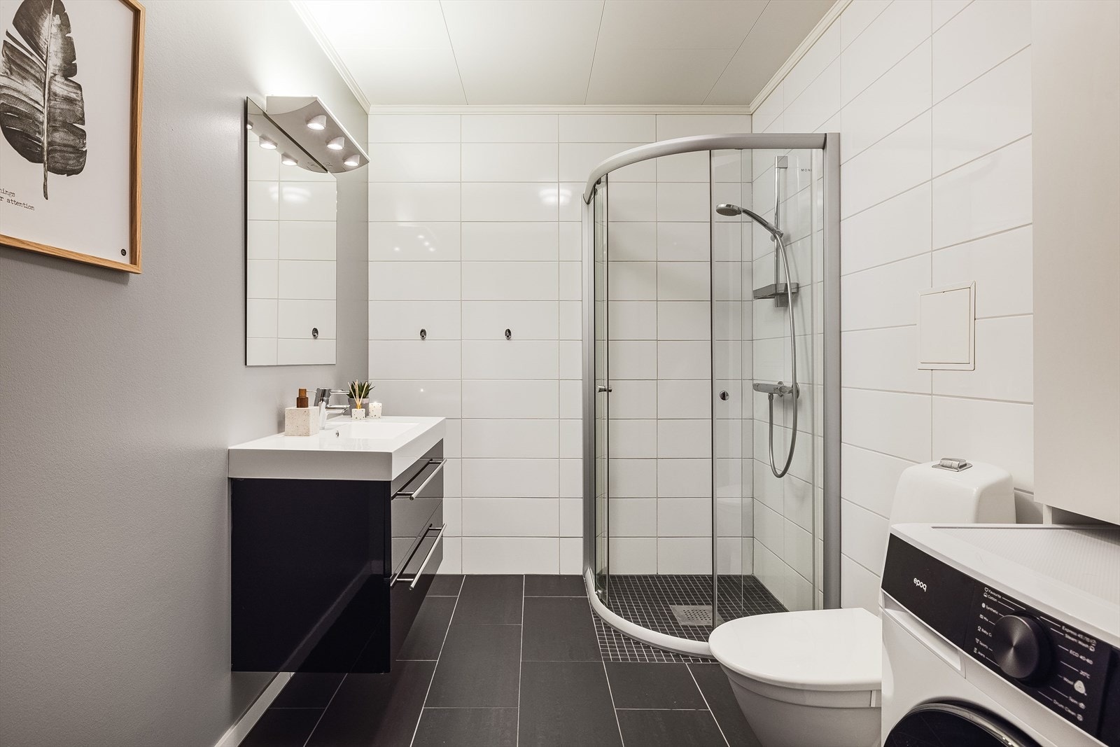 Pent bad med servant på innredning, toalett og dusjhjørne. Varmekabler i gulvet. Galleribilde