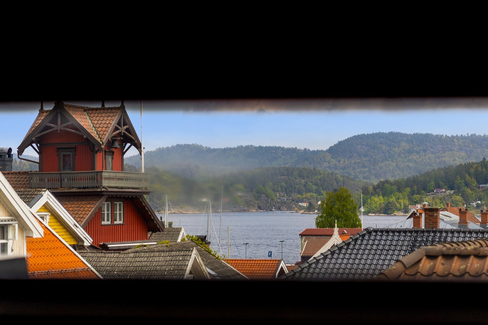 Utsikt mot Eidangerfjorden og den gamle brannstasjonen fra et mindre vindu i gangen i 3. etasje. Galleribilde