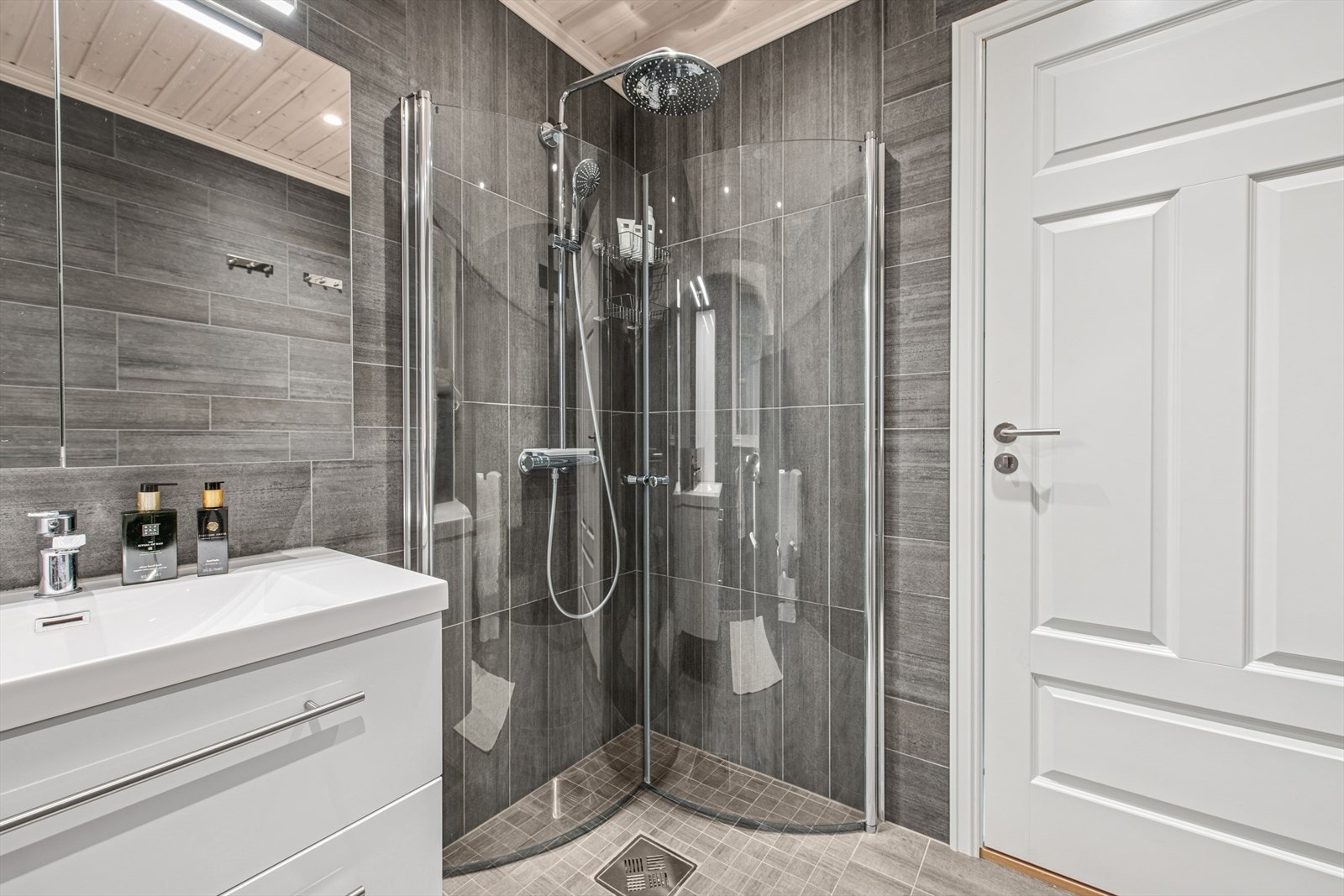 Lekkert bad med dusjnisje og innredning som gir godt med oppbevaringsplass Galleribilde