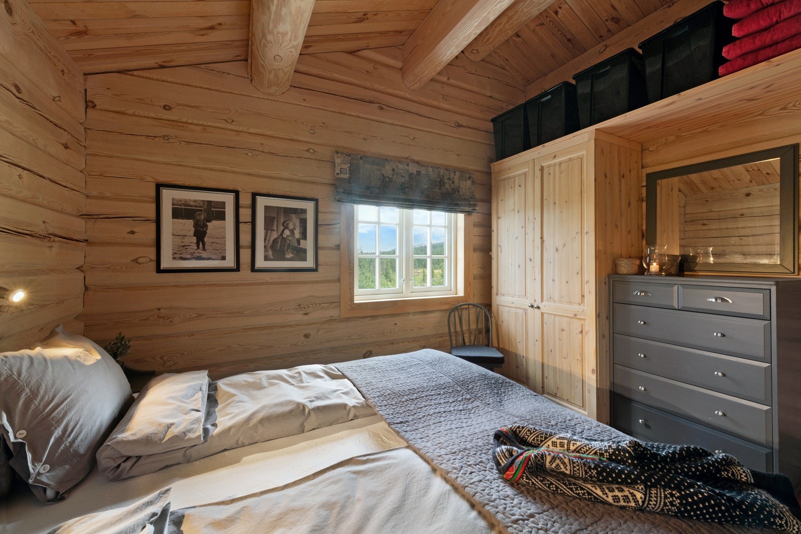 Soverom med tømmervegger, dobbeltseng, kommode og garderobeskap. Galleribilde