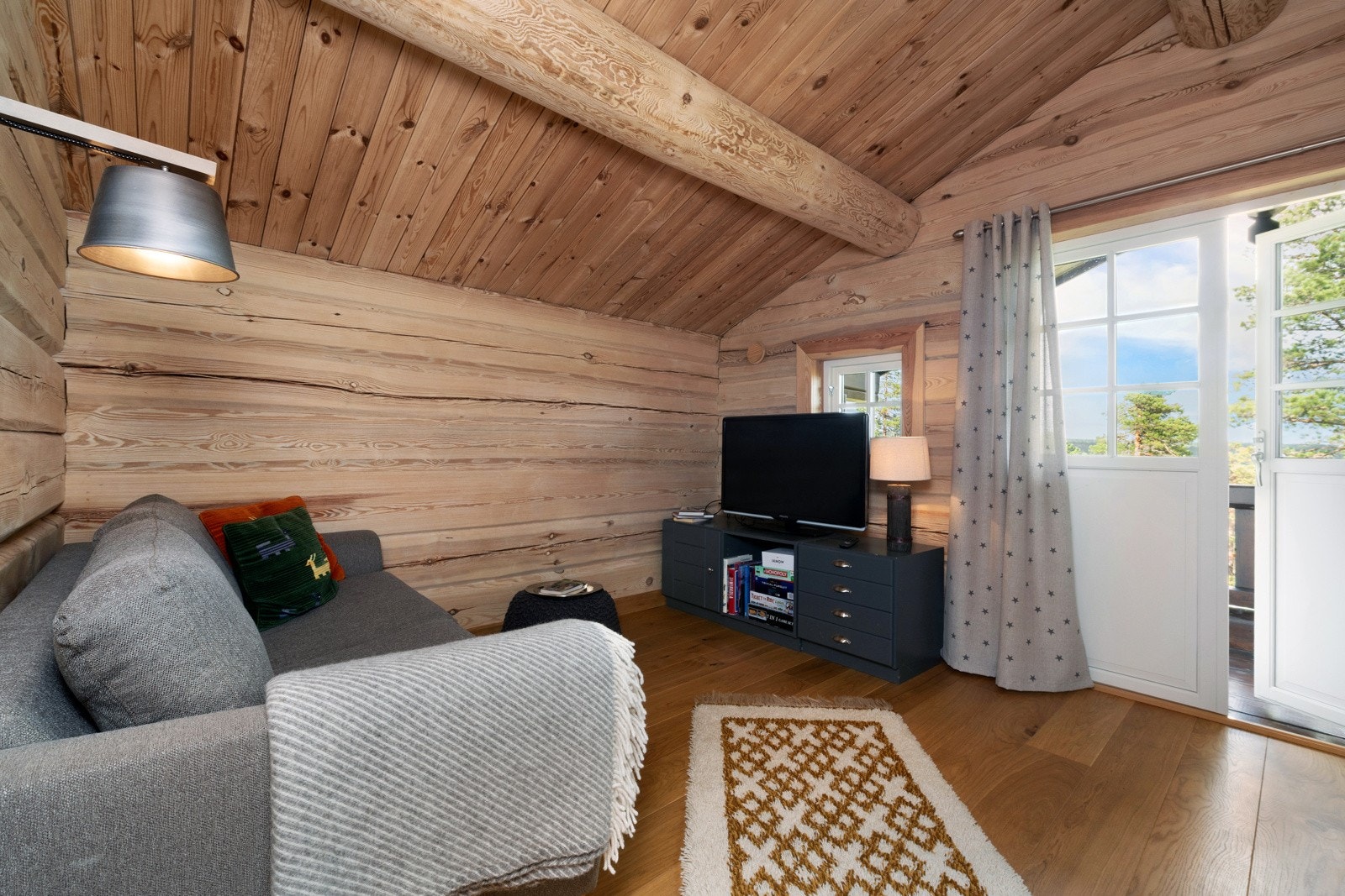 Loftstue med plass til sofa og tilhørende møblement, samt utgang til balkong. Galleribilde