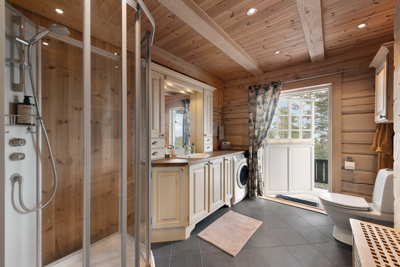 Bad med dusjkabinett, toalett, vaskemaskin og servant Galleribilde