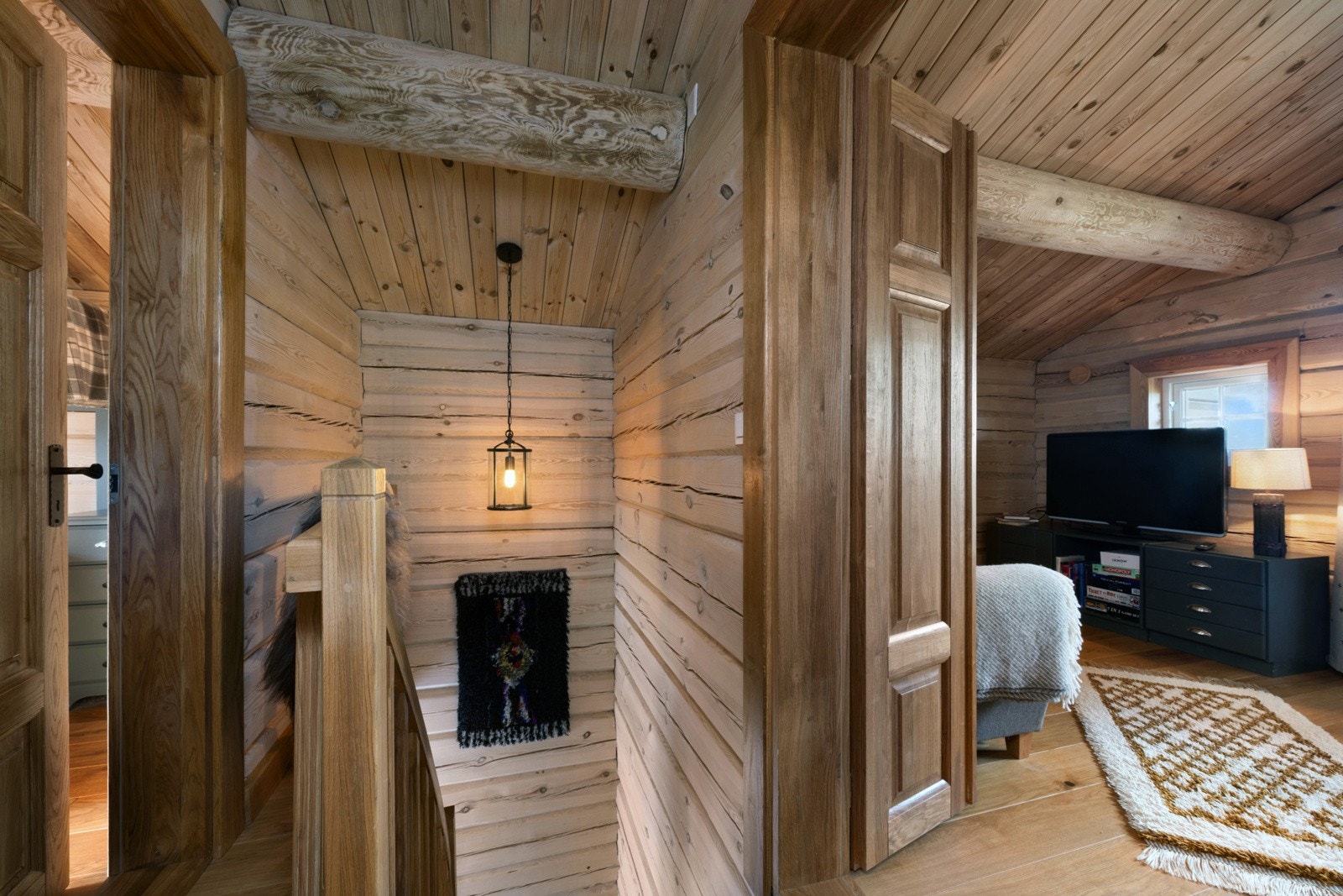 Trivelig gang med trepanel og koselig belysning, som leder inn til en loftstue. Galleribilde