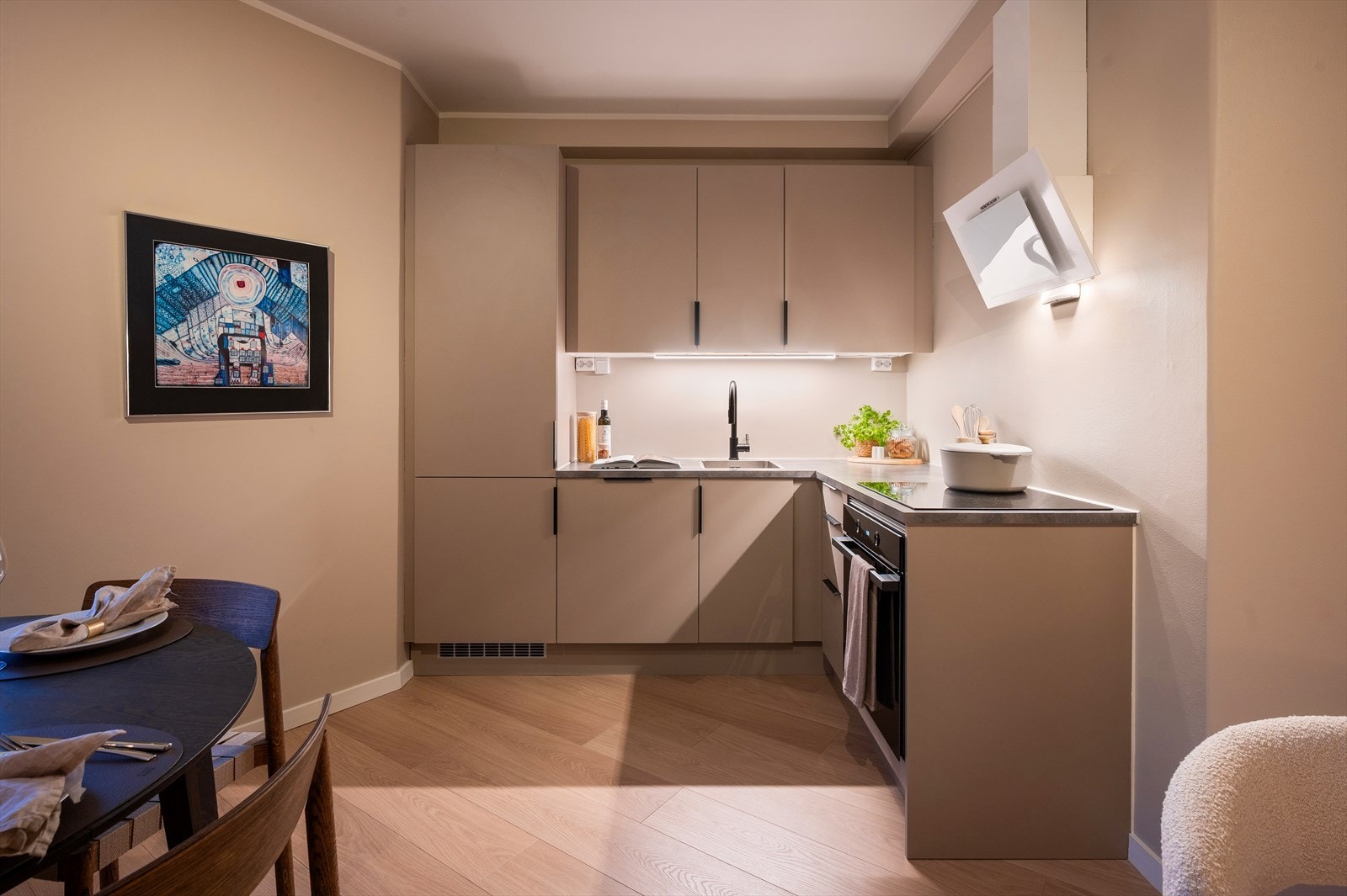 Moderne og pent kjøkken med ny innredning fra HTH (2024). Kjøkkenet har god skap- og benkeplass med glatte fronter og laminat benkeplate med nedfelt vaskekum. Galleribilde