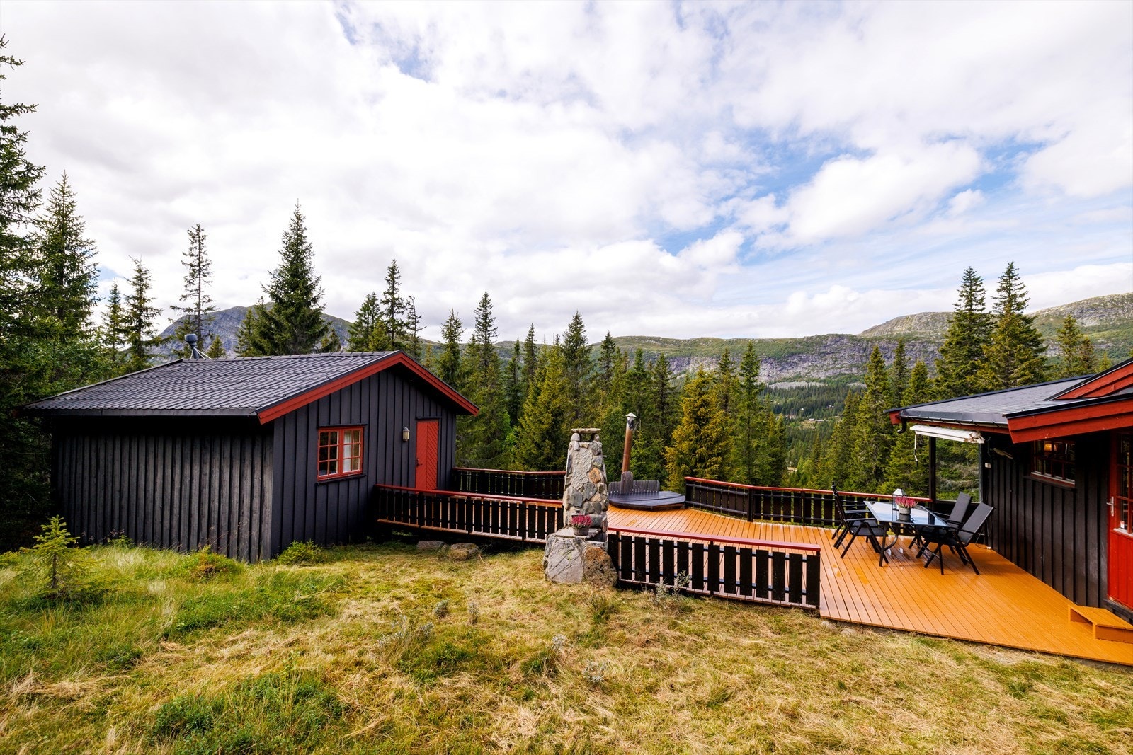 Stor terrasse som binder hytte og frittstående bygg sammen. Galleribilde