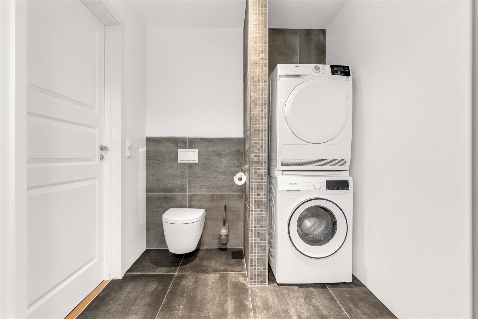 Innredningen består av nedfelt servant med underskuffer og 1-greps blandebatteri, dusjhjørne med glassdører, vegghengt toalett og opplegg for vaskemaskin. Galleribilde