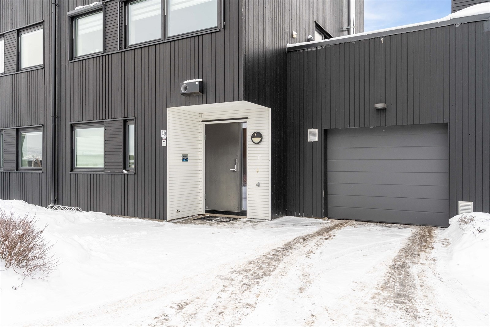 Overbygget inngangsparti med utebelysning. Galleribilde