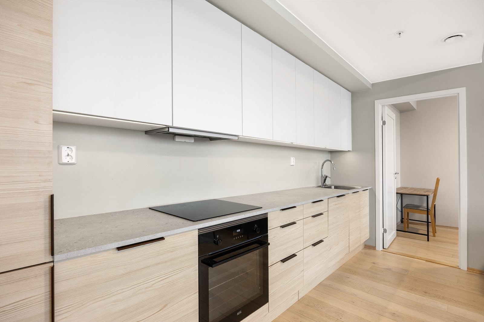 Moderne kjøkkeninnredning med glatte fronter, laminat benkeplate og kjøkkenkum. Galleribilde