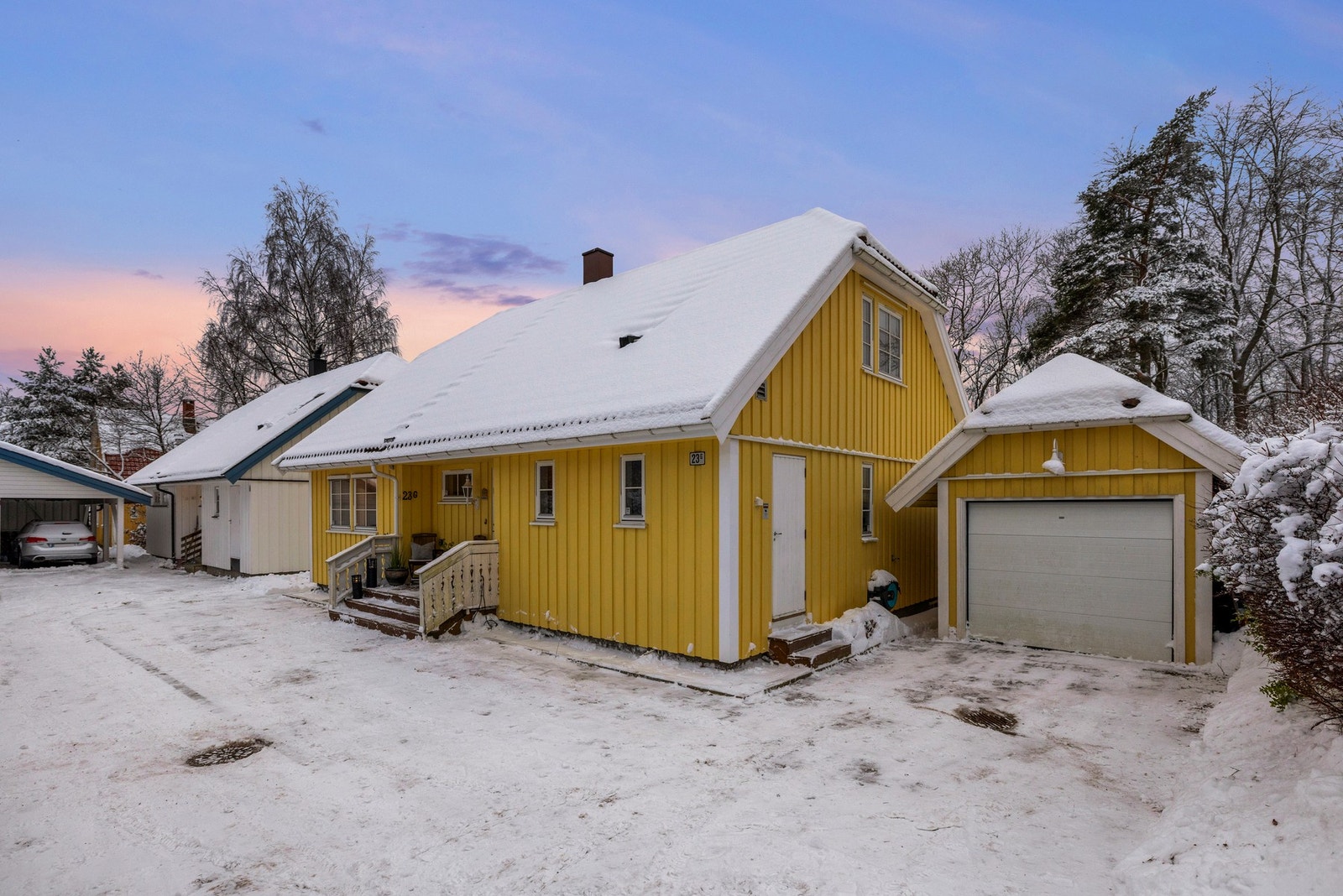 Ved siden av huset er det en garasje med oppstillingsplass foran Galleribilde