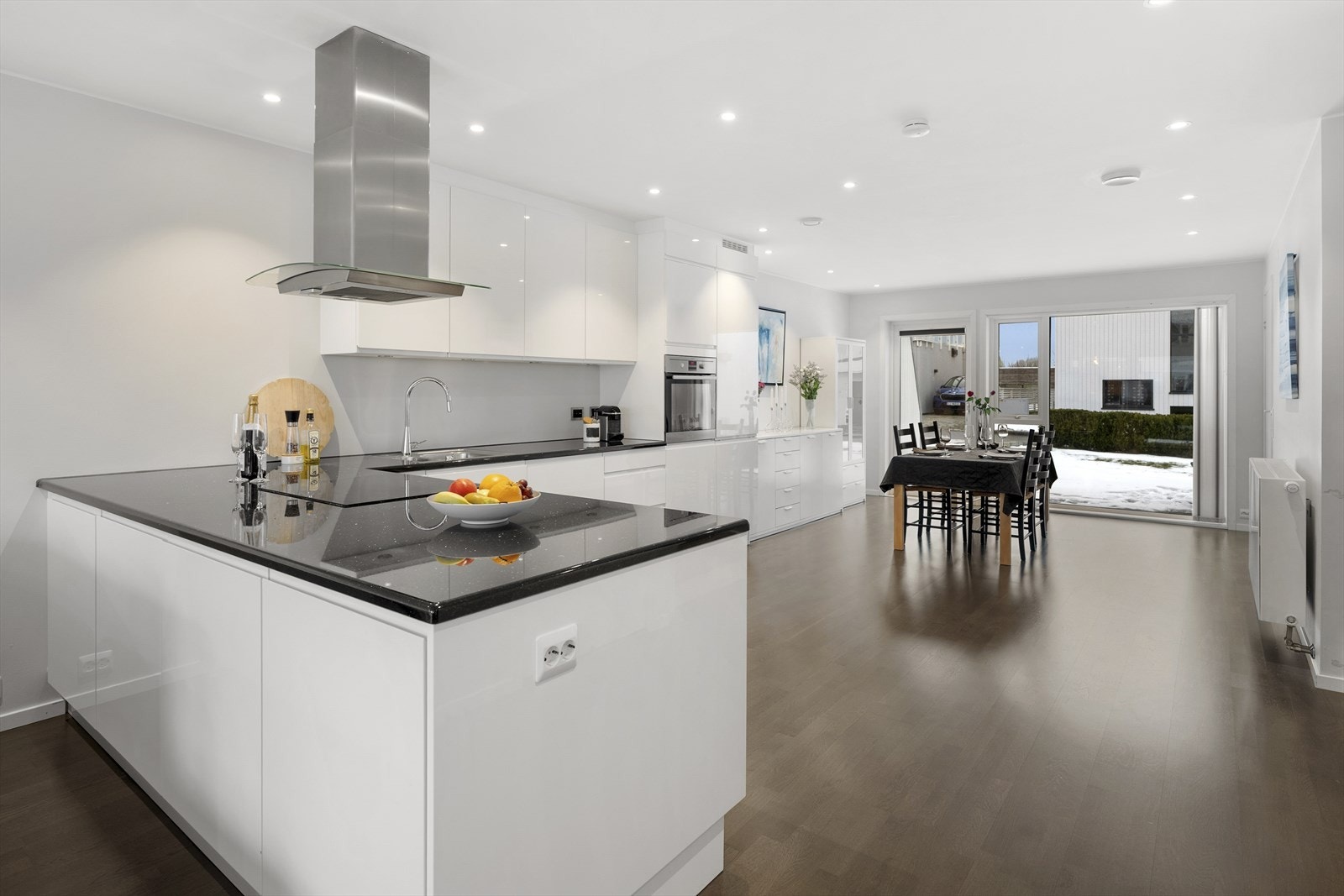 Kjøkkenet er levert av AUBO og har hvit innredning i lekker kombinasjon med benkeplate i stein. Galleribilde