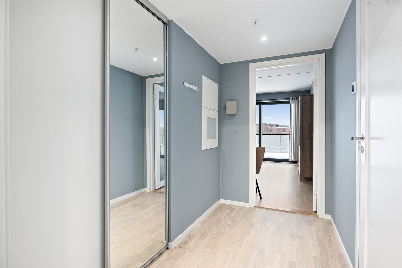 Man kommer inn i en innbydende entré med skyvedørsgarderobe Galleribilde