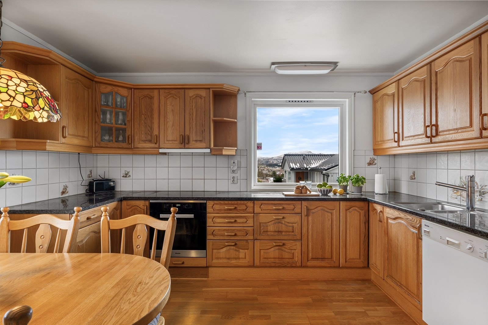 Kjøkkenet har godt med skap og benkeplass Galleribilde