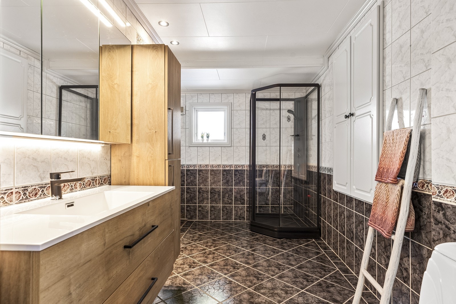 Hovedbadet er romslig og flislagt, med en moderne baderomsinnredning og dusjhjørne. Galleribilde