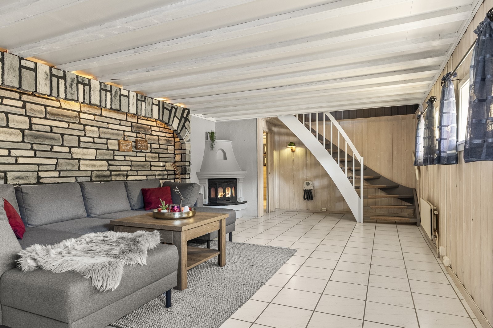 Kjellerstuen er et stort og anvendelig rom med peis og flislagt gulv. Galleribilde