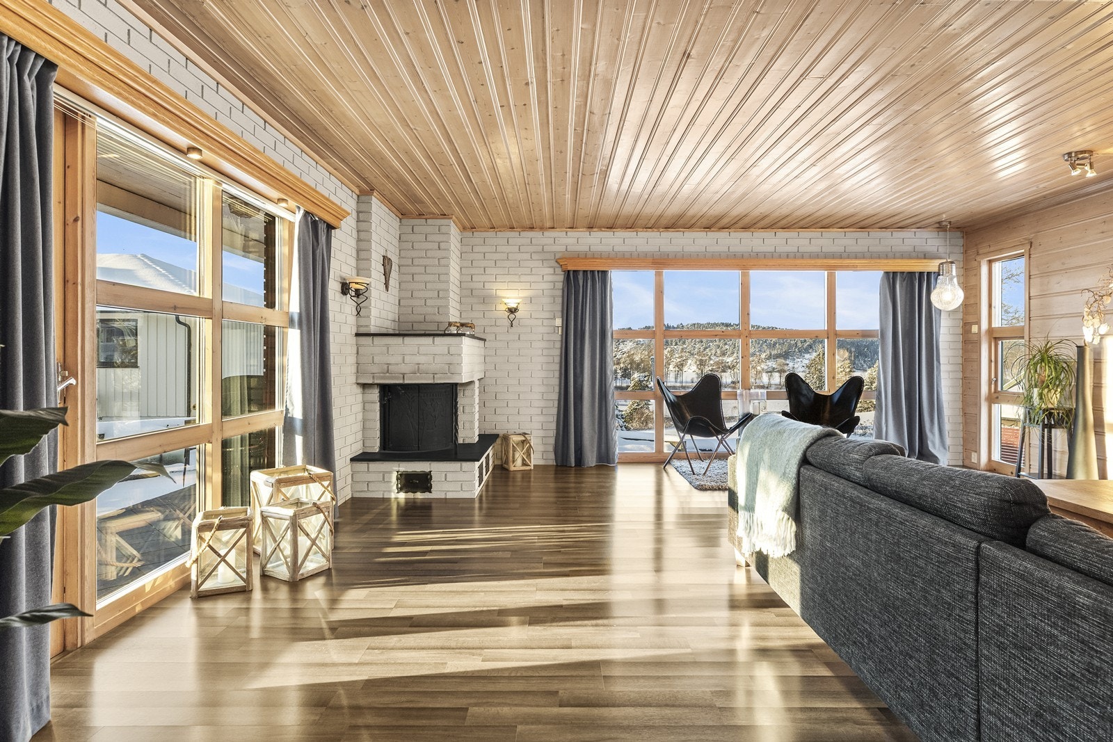 Stuen har store vindusflater som gir godt med dagslys, og en murt peis som gir varme og hygge. Galleribilde