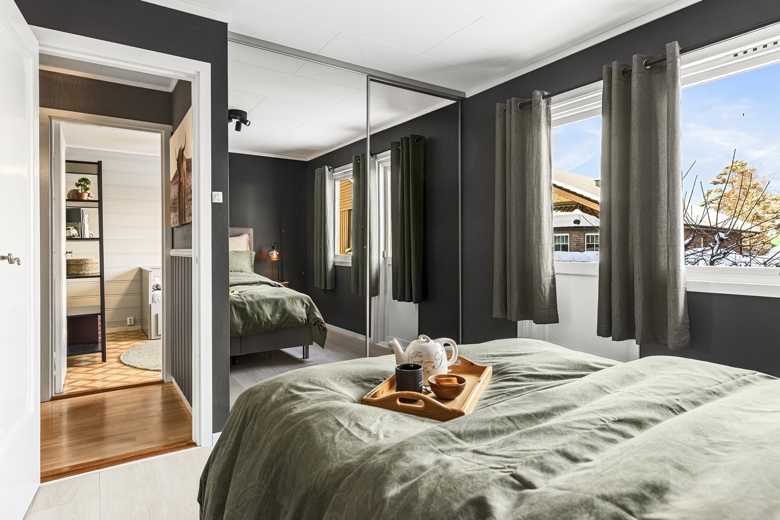 En stor skyvedørsgarderobe med speilfronter gir rikelig med oppbevaringsplass. Galleribilde