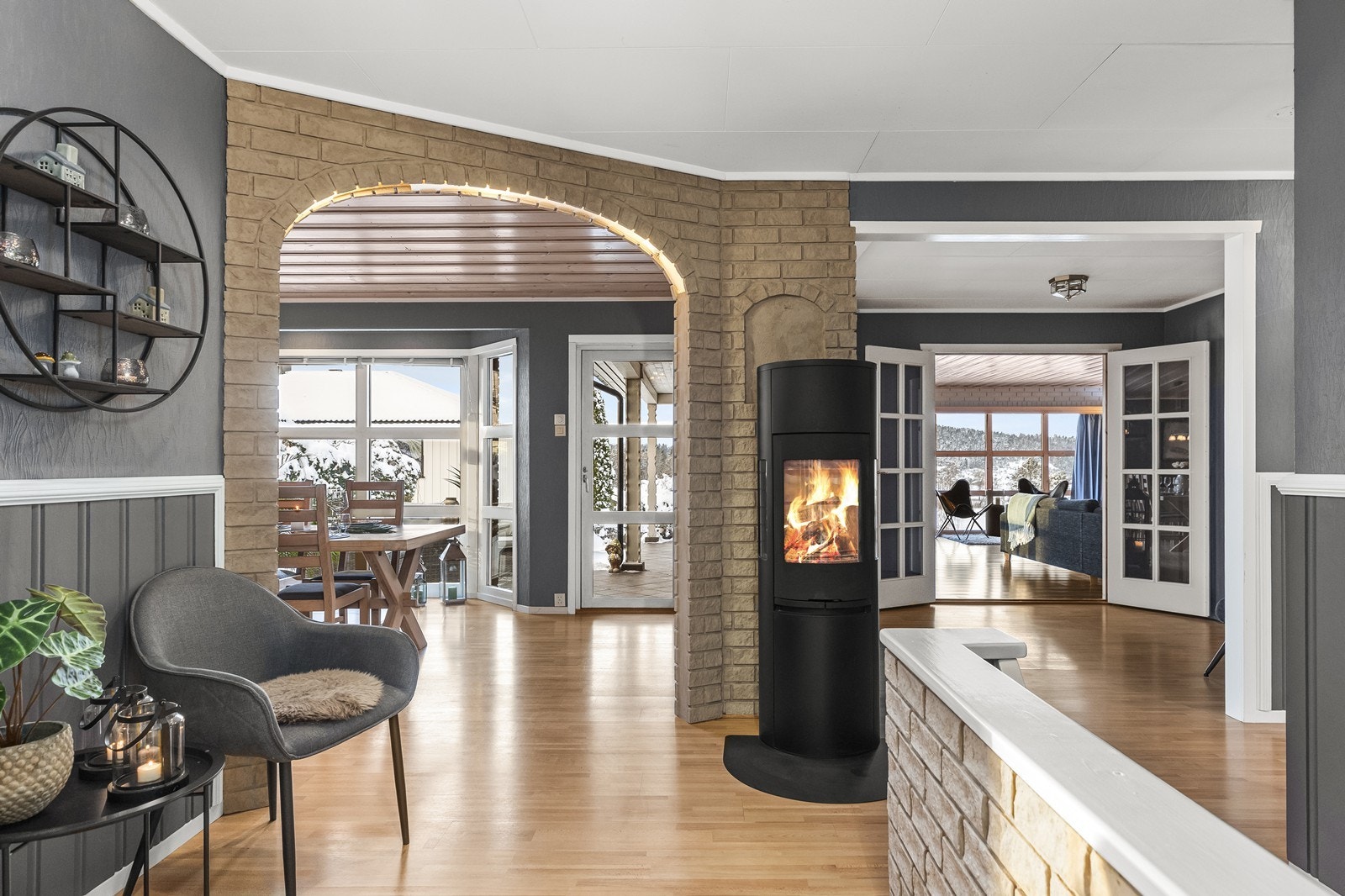 En vedovn fungerer som et sentralt punkt mellom stuene og gir ekstra varme, doble glassdører åpner inn mot stuen. Galleribilde