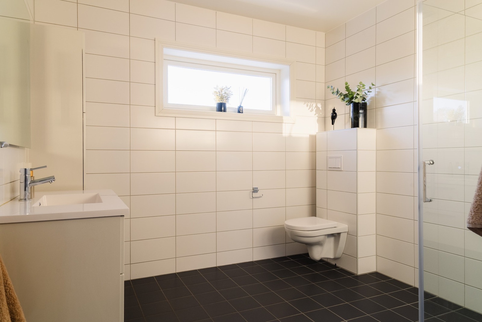 Baderommet ligger i andre etasje og er fra 2018. Rommet fremstår moderne og tidløst med flislagte overflater. Galleribilde