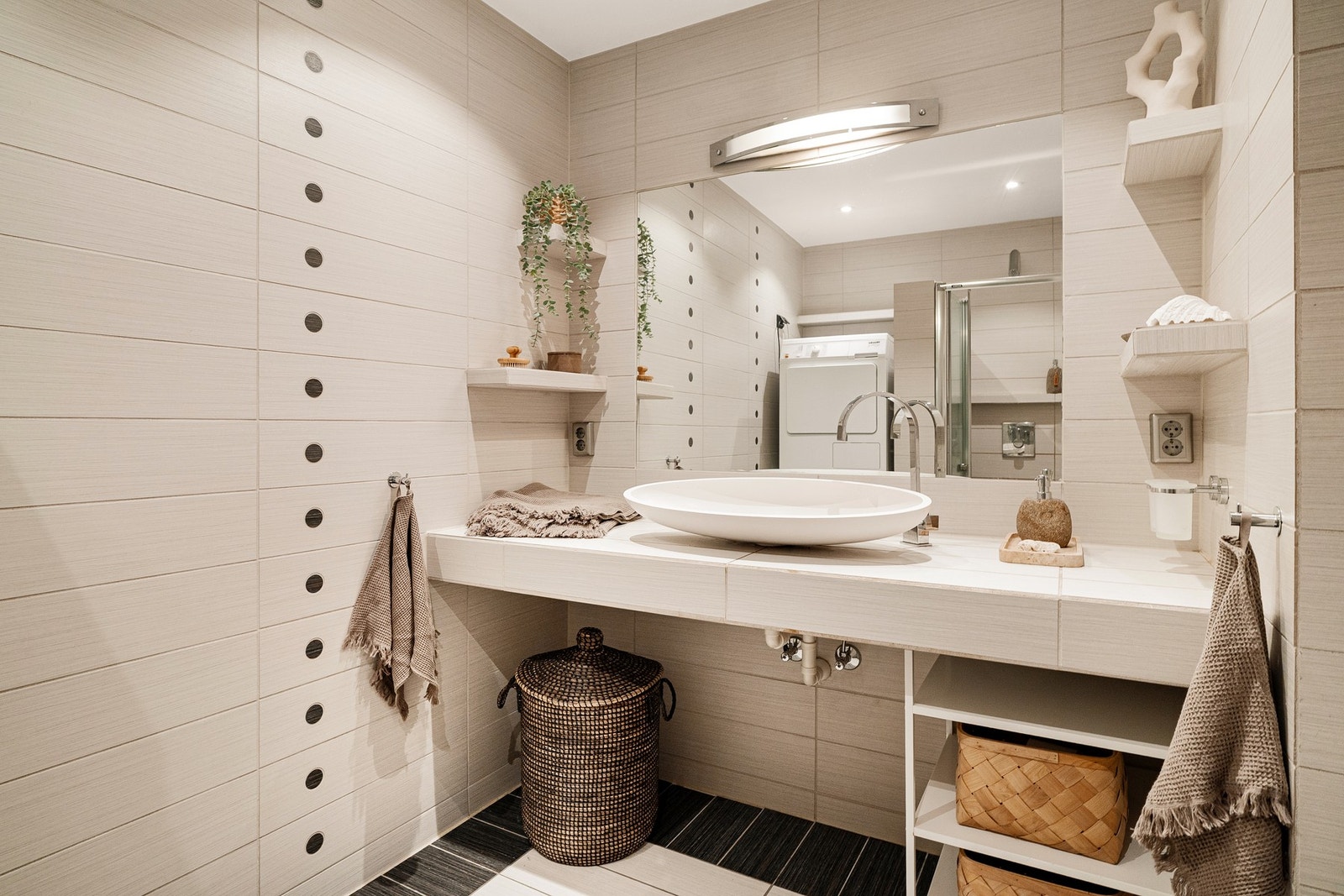 Plasstilpasset baderomsinnredning gir et stilrent uttrykk. Innmurt speil i vegg og flislagte hyller. Galleribilde