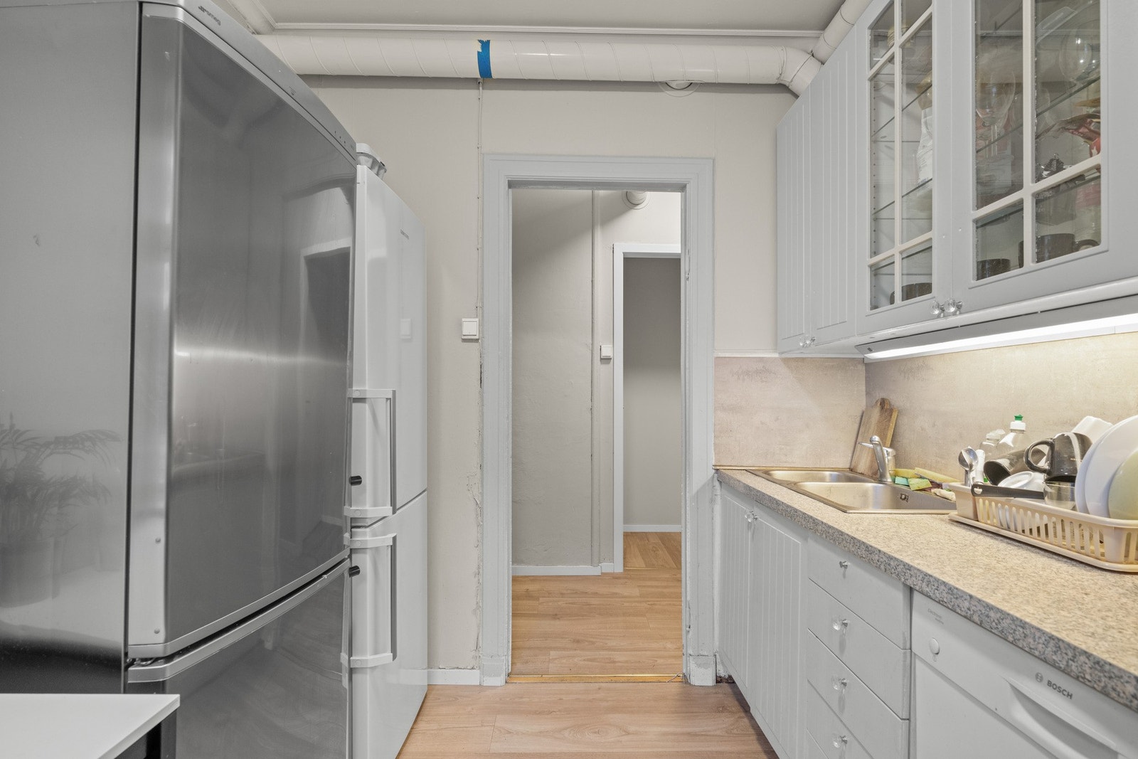 Kjøkkeninnredning i 2.etasje med slette og profilerte fronter, ett av overskapene har glassfront, laminat benkeplate, over
benkeplaten er det benyttet kitchenboard, stål oppvaskkum, ventilator. Galleribilde