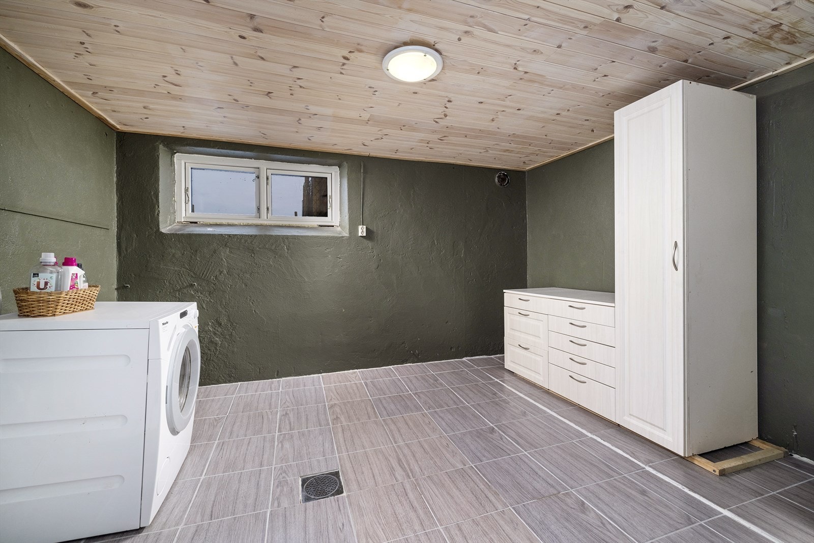 Romslig vaskerom i kjeller med innredning og opplegg for vaskemaskin. Galleribilde