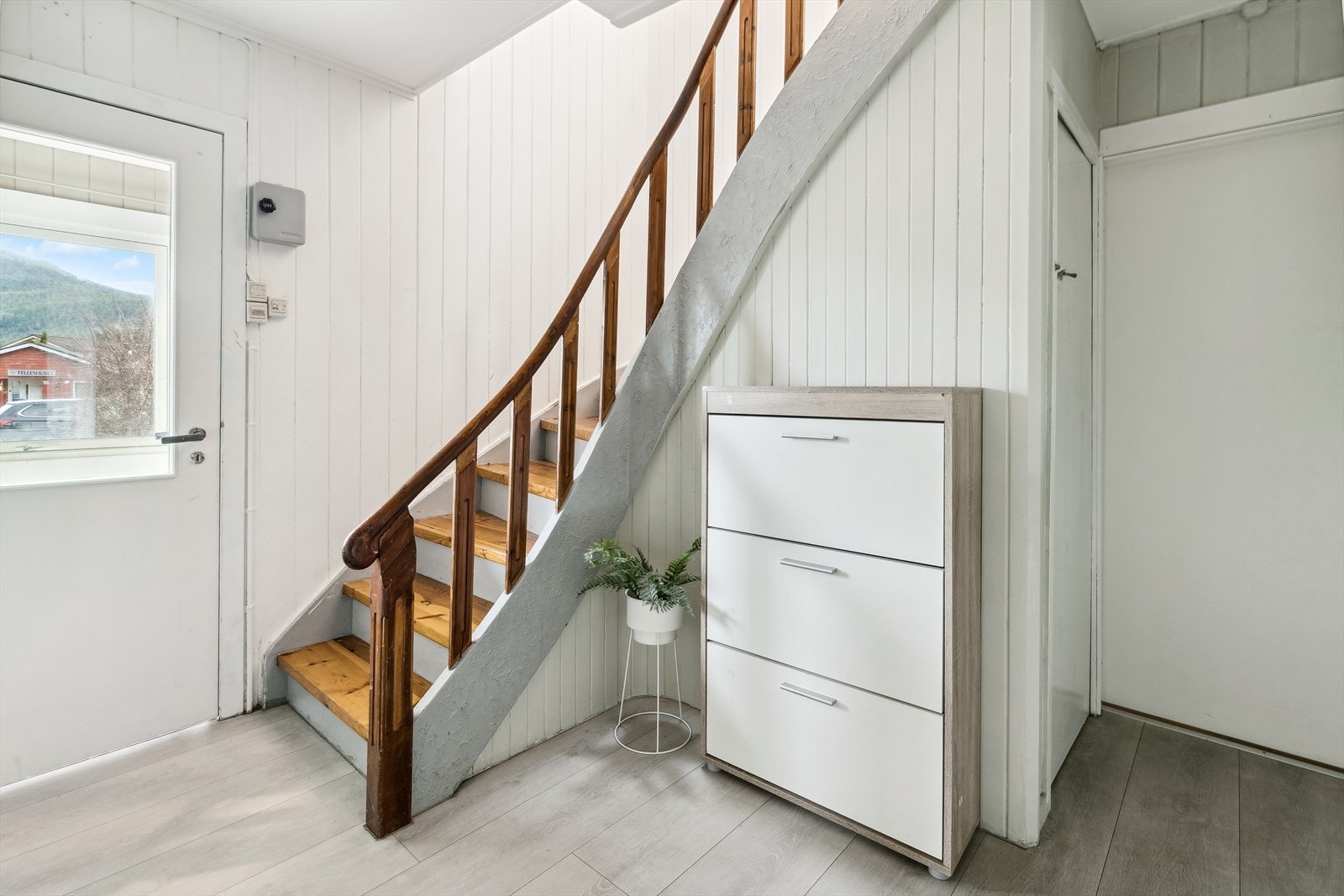 Entré i dør ved trapp til loft. I gang er det også laminat på golv. På veggar er det malt panel og to veggar med sparkla struktur. Galleribilde