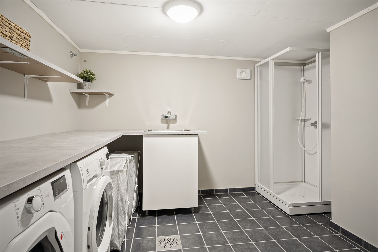 Boligen har et praktisk vaskerom etablert i kjelleretasjen med flislagt gulv med gulvvarme og god plass til både klesbretting og oppbevaring. Galleribilde