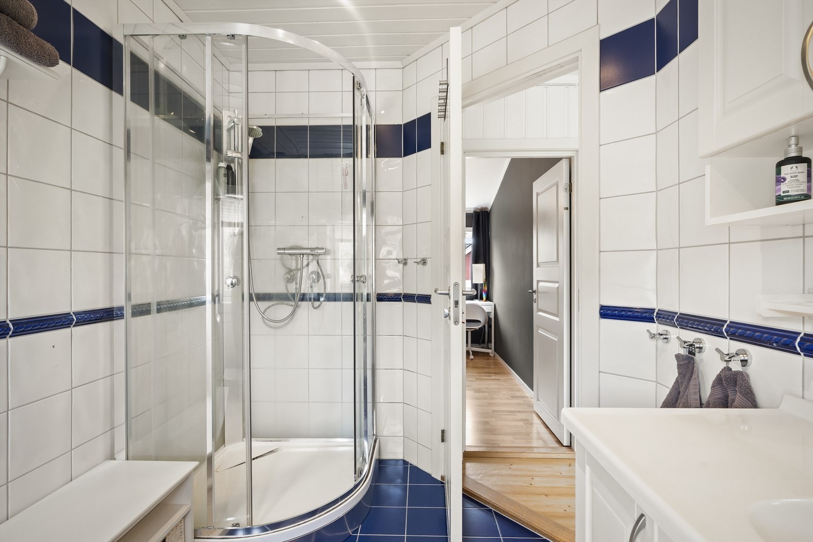 Badet er innredet med servantinnredning, gulvstående toalett og dusjkabinett. Galleribilde