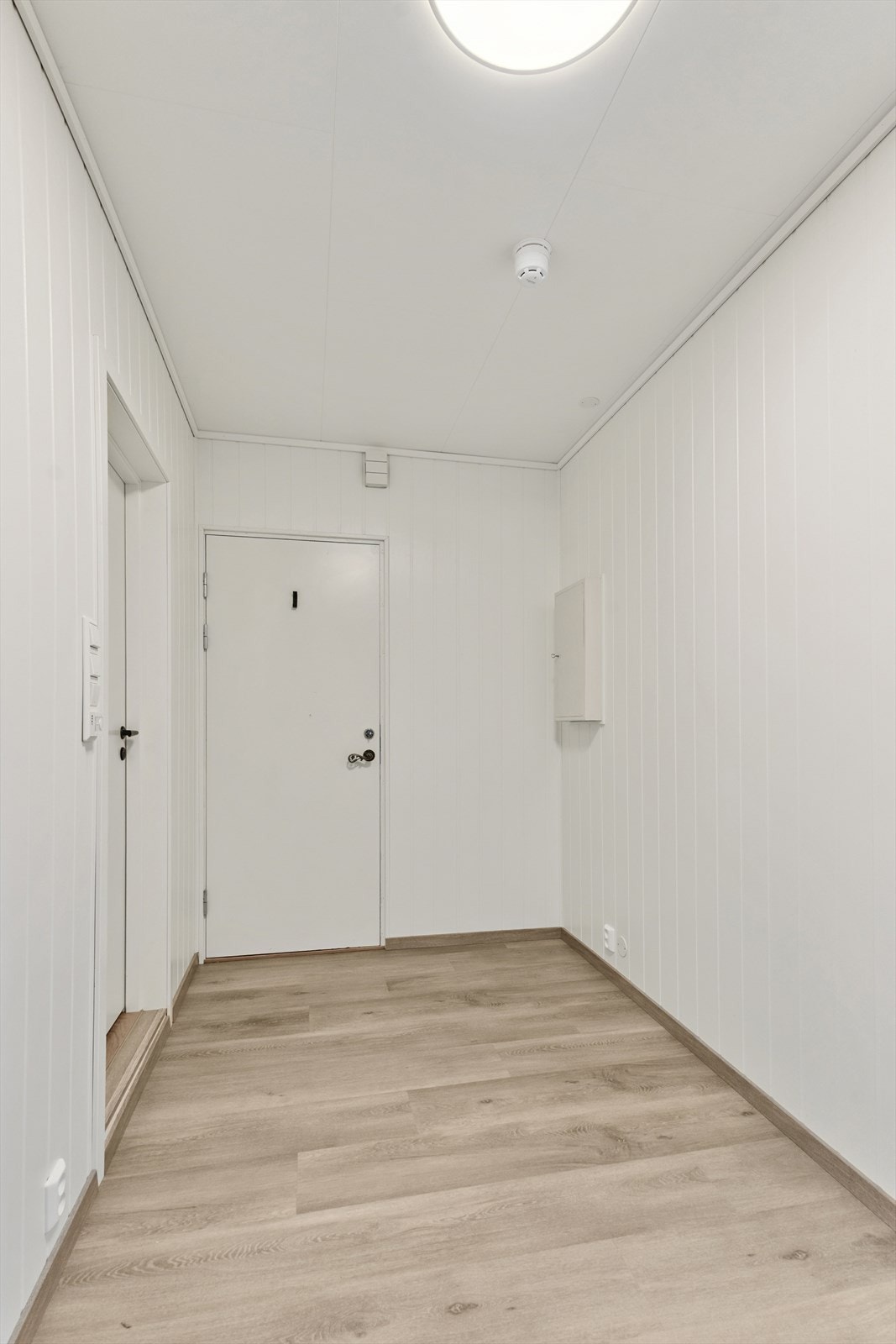 Velkommen inn! Her har du plass for oppbevaring i entré.
Det er lagt laminat på golv og malte plater på vegg. Galleribilde