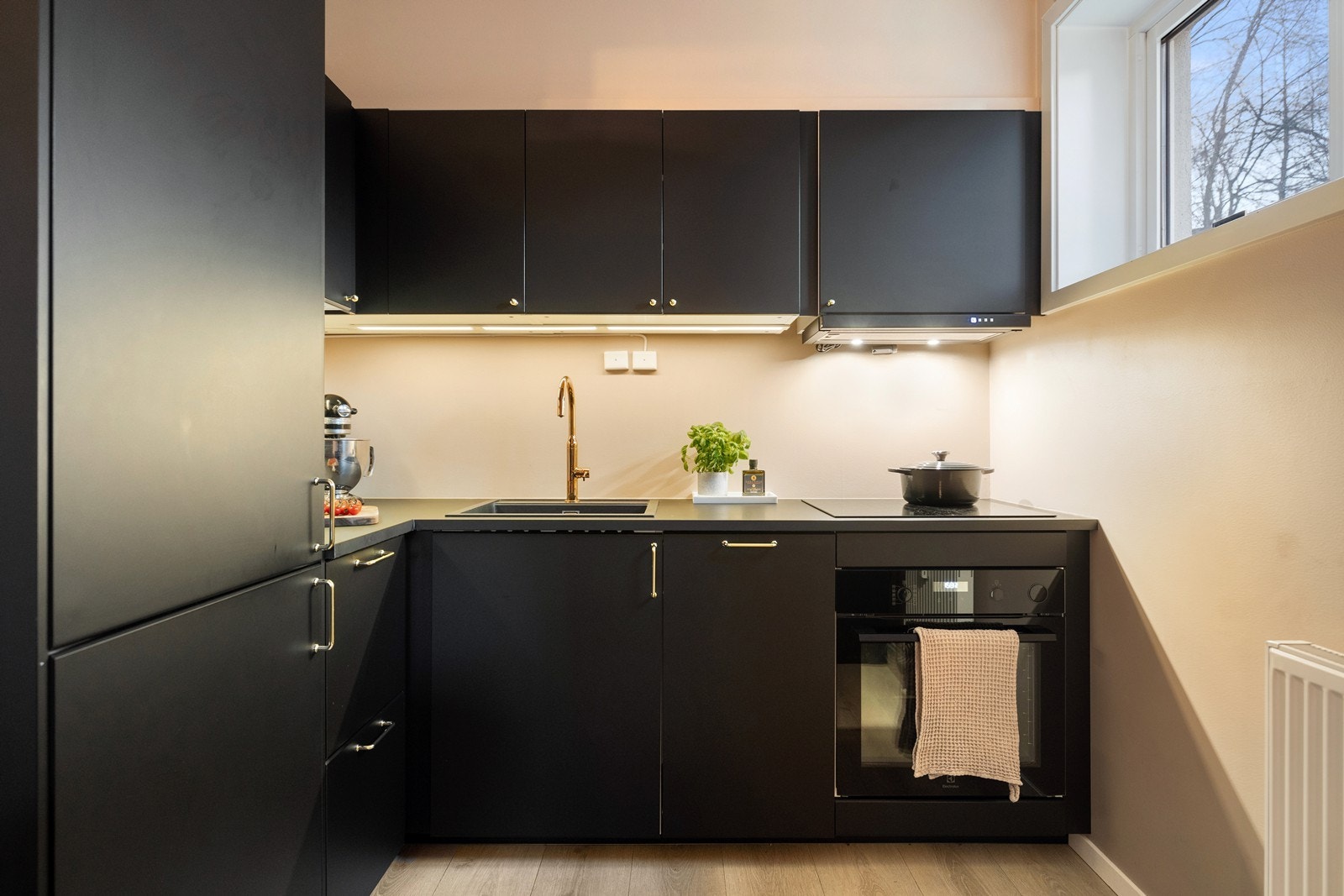 Innredningen består av laminat benkeplate, ventilator vifte og nedfelt kum. Videre er det integrert komfyr, induksjon platetopp, oppvaskmaskin og kjøl/frys som medfølger leiligheten ved salg. Galleribilde