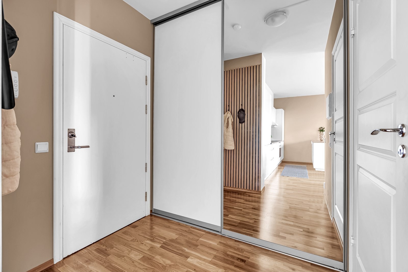 Innbydende entré med stor skyvedørsgarderobe perfekt for oppbevaring. Ellers er det god plass til skoskap, knagger eller annen oppbevaring. Porttelefon på vegg Galleribilde